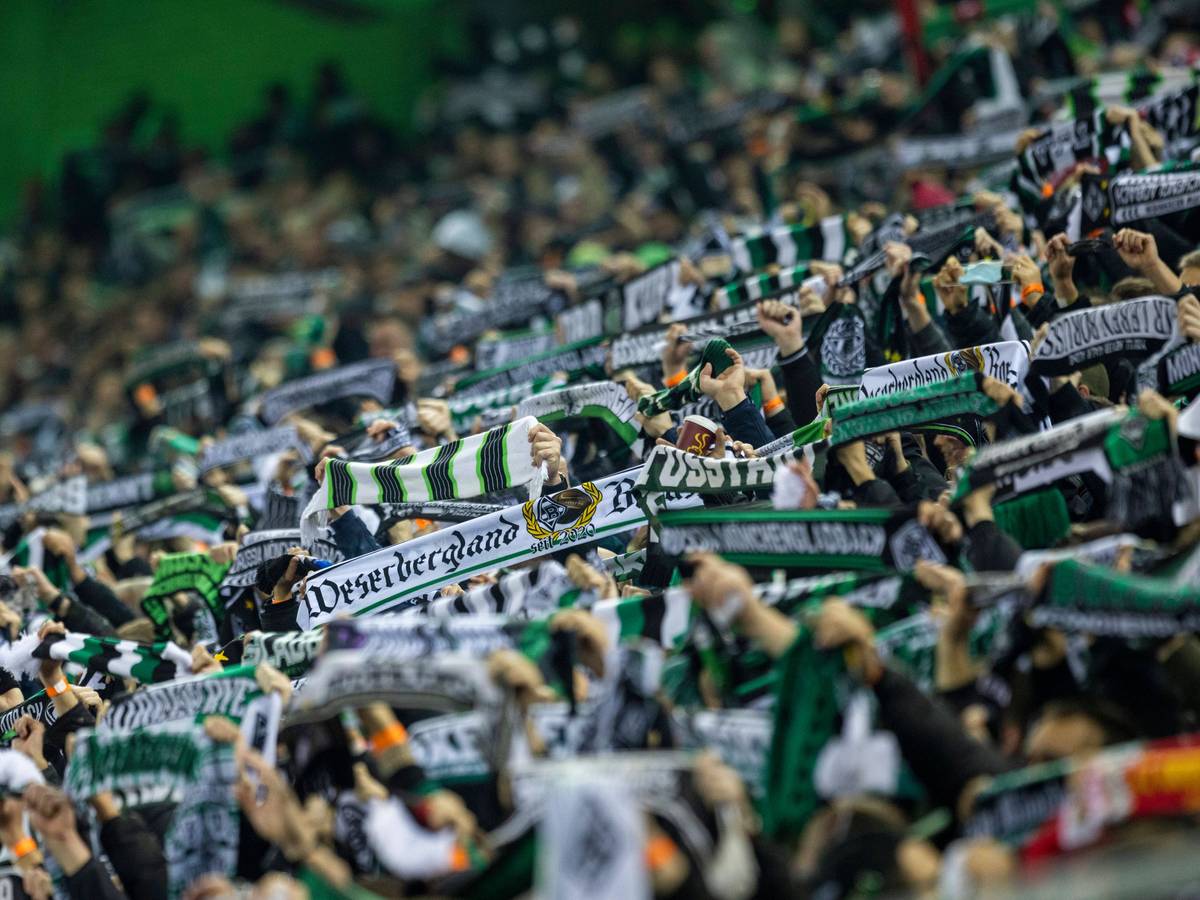 Fans von Fußball-Bundesligist Borussia Mönchengladbach am 20. November 2021 in der Nordkurve im Borussia-Park. Sie halten ihre Schals in die Höhe.