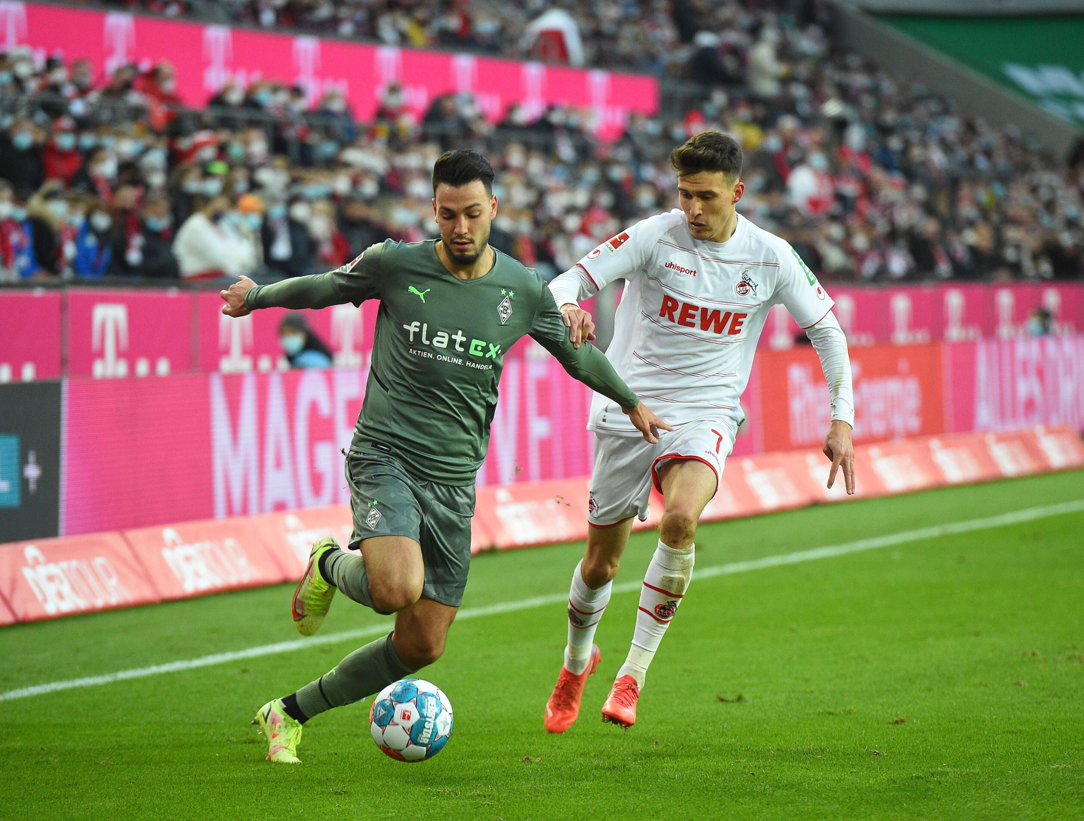 Ramy Bensebaini (l.) von Borussia Moenchengladbach im Zweikampf mit Dejan Ljubicic (r.) vom 1. FC Köln am 27. November 2021.