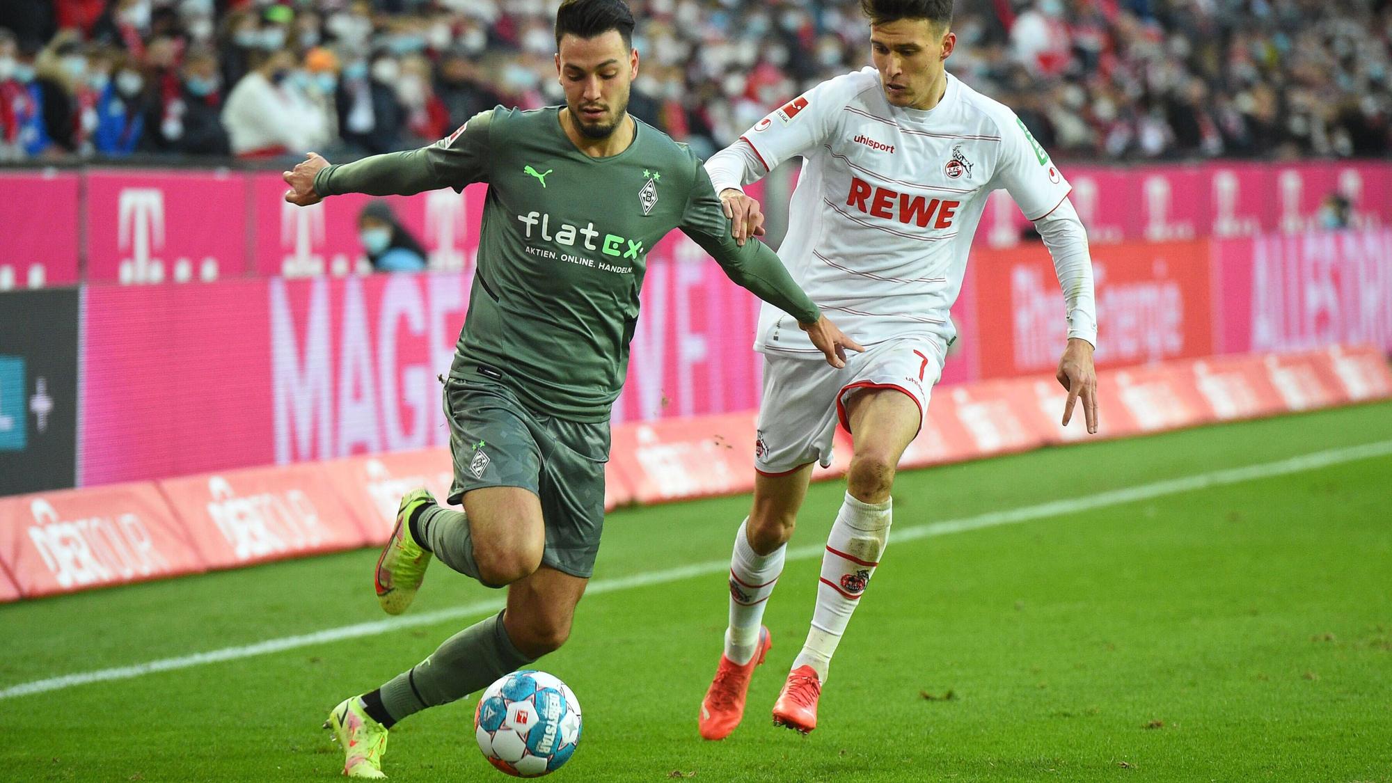 Ramy Bensebaini (l.) von Borussia Moenchengladbach im Zweikampf mit Dejan Ljubicic (r.) vom 1. FC Köln am 27. November 2021.