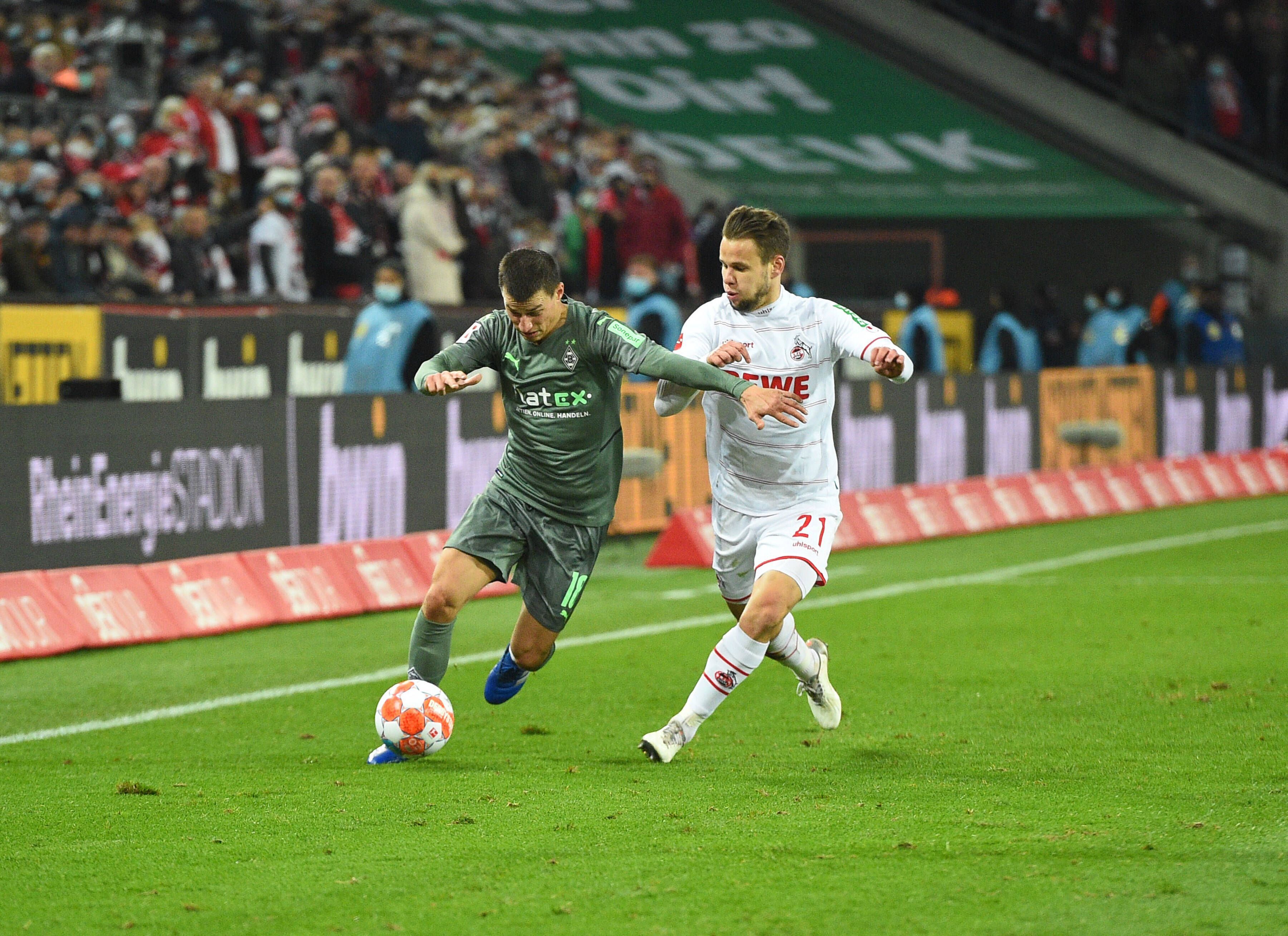 Stefan Lainer (l.) von Borussia Mönchengladbach mit dem Ball am Fuß, versucht Louis Schaub (r.) vom 1. FC Köln am 27. November 2021 zurückzuhalten.