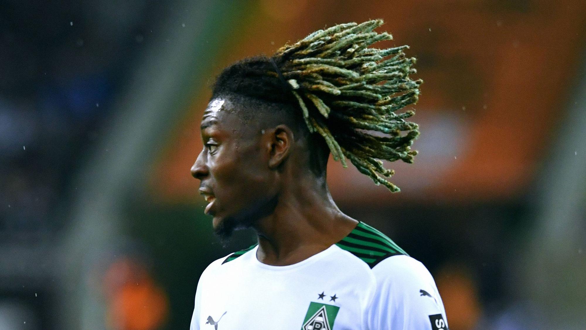 Manu Koné fällt mit starken Leistungen und einer schrillen Frisur in der Fußball-Bundesliga auf. Der Mittelfeldspieler steht bei Borussia Mönchengladbach bis 2025 unter Vertrag. Auf diesem Foto ist er am 31. Oktober 2021 im Borussia-Park zu sehen. Seine Haare wehen im Wind.