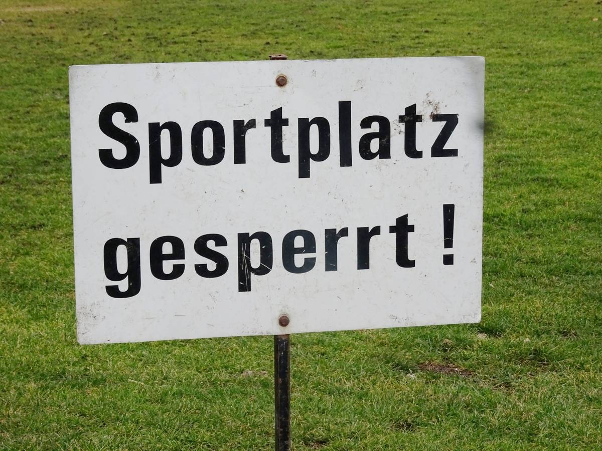 Sportplatz gesperrt! Dieses Symbolfoto stammt vom 19. Februar 2021. Zu sehen ist ein Schild, im Hintergrund ist der Spielfeldrasen.