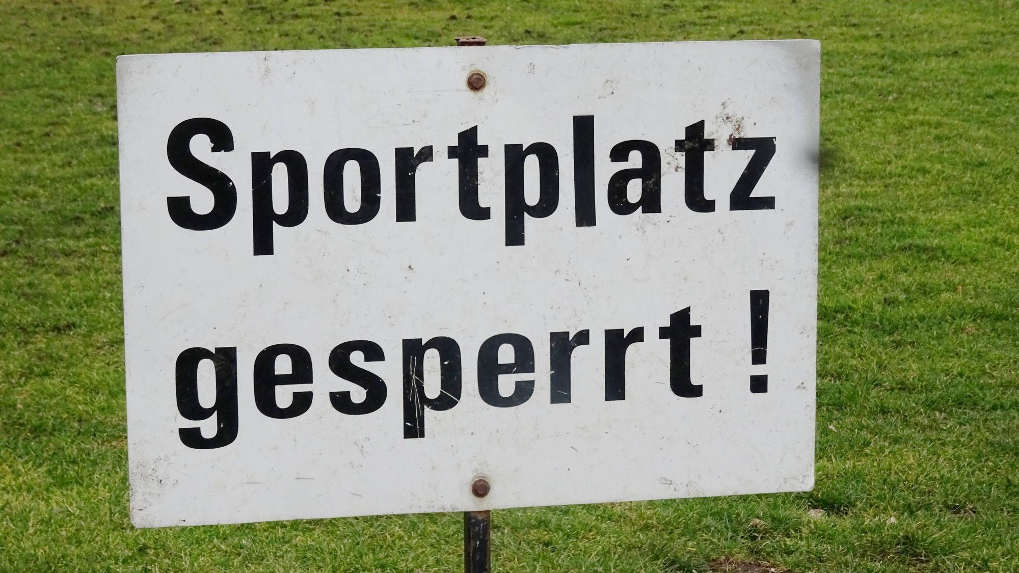 Sportplatz gesperrt! Dieses Symbolfoto stammt vom 19. Februar 2021. Zu sehen ist ein Schild, im Hintergrund ist der Spielfeldrasen.