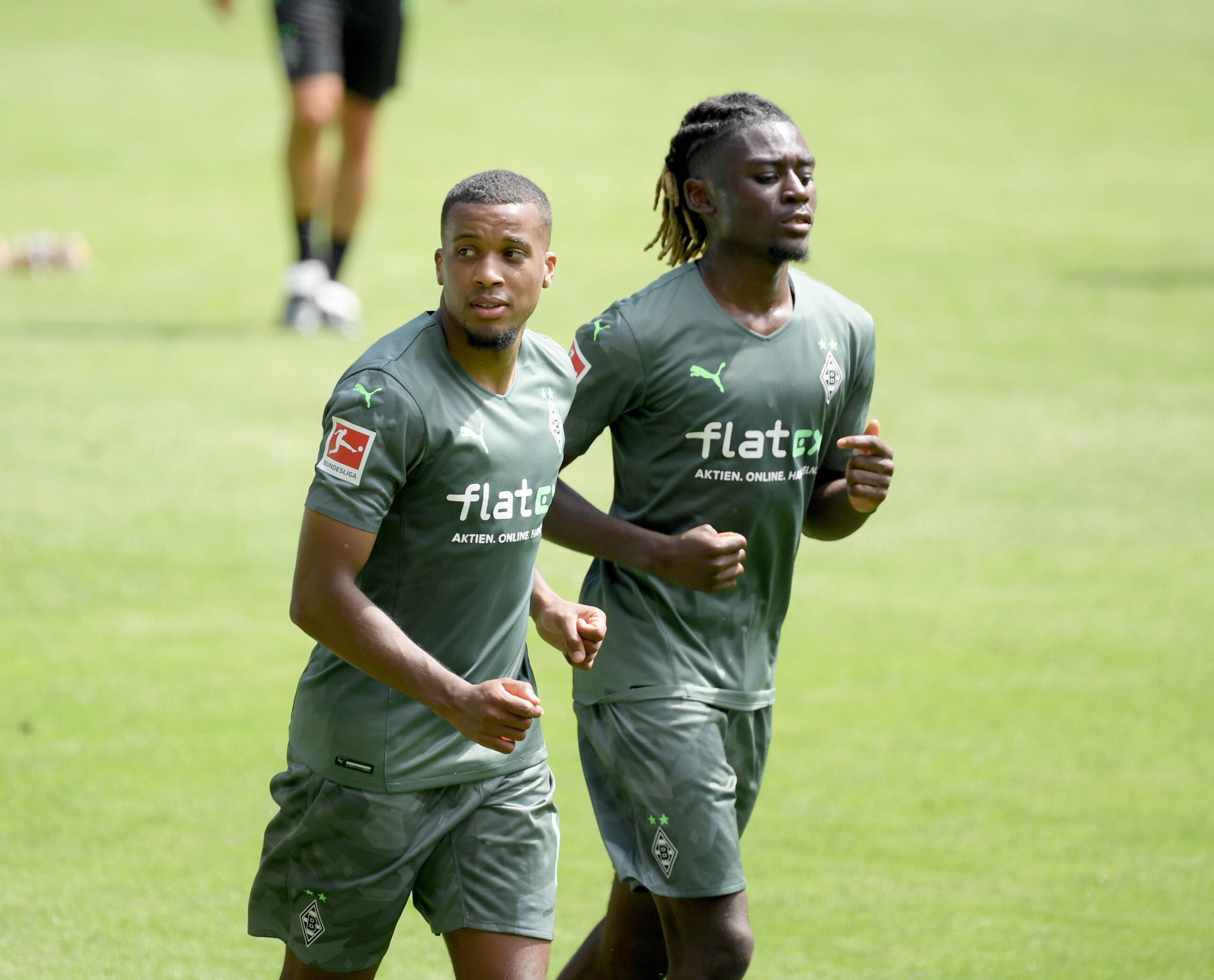 Zu Beginn seiner Zeit bei Fußball-Bundesligist Borussia Mönchengladbach hatte Manu Koné (r.) noch blonde Locken. Auf diesem Bild ist der Franzose gemeinsam mit Alassane Plea (l.) am 3. Juli 2021 im Borussia-Park zu sehen. Kone schaut nach vorne.