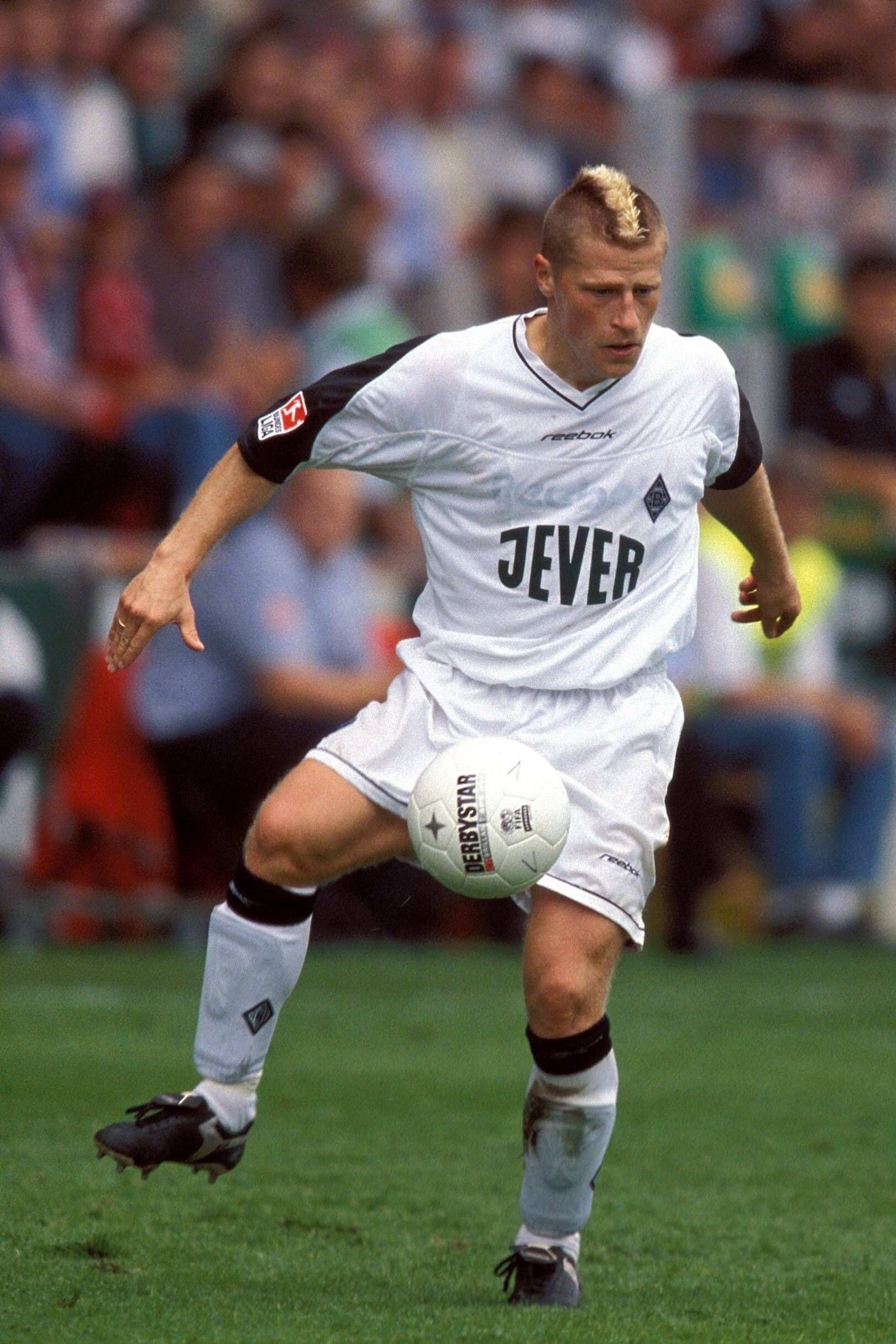 Für schrille Frisuren bei Borussia Mönchengladbach hat auch schon mal der heutige Fohlen-Manager Max Eberl gesorgt. Auf diesem Foto ist der 48-Jährige am 10. August 2002 als „Irokese“ im VfL-Trikot zu sehen. Eberl schaut auf den Ball.