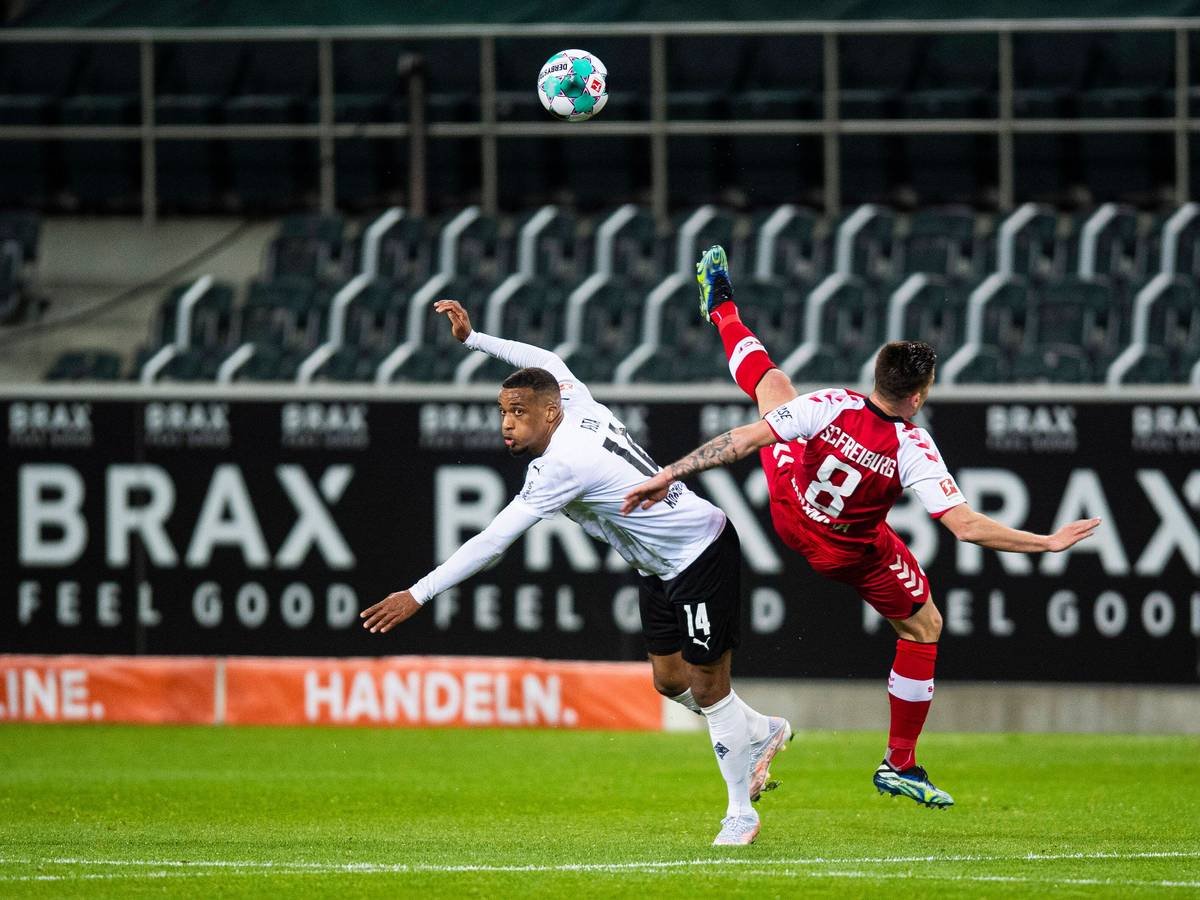 Alassane Plea (l.) von Borussia Mönchengladbach im Bundesliga-Duell mit Freiburgs Baptiste Santamaria (r.) am 3. April 2021 im Borussia-Park.