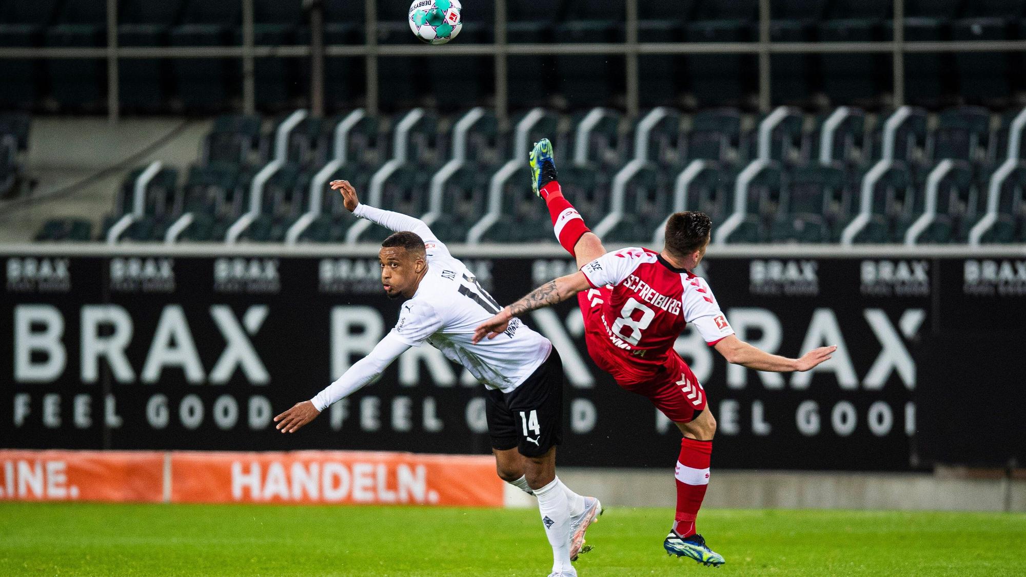 Alassane Plea (l.) von Borussia Mönchengladbach im Bundesliga-Duell mit Freiburgs Baptiste Santamaria (r.) am 3. April 2021 im Borussia-Park.