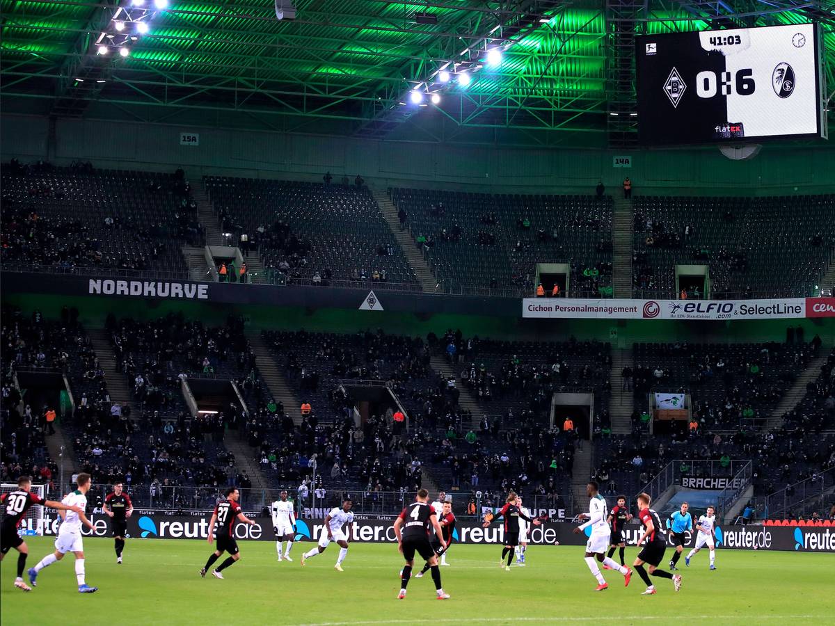 Borussia Mönchengladbach hat eine historische Niederlage am 6. Dezember 2021 erlebt. Gegen den SC Freiburg setzte es eine 0:6-Pleite. So hoch hatten die Fohlen zuvor noch nie im Borussia-Park verloren. Auf dem Platz sind Spieler beider Mannschaften zu sehen, derweil zeigt die Videowand das Ergebnis an.