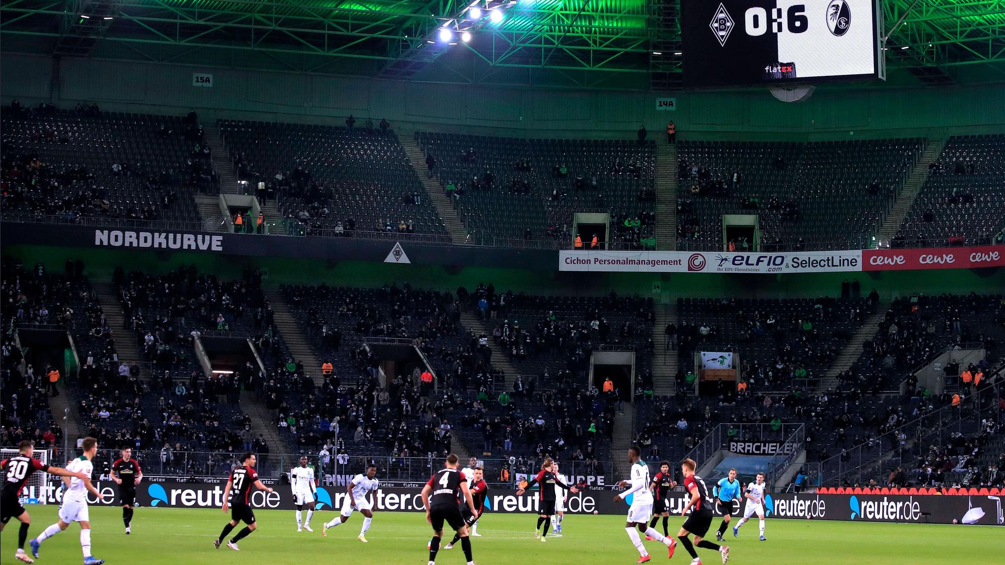 Borussia Mönchengladbach hat eine historische Niederlage am 6. Dezember 2021 erlebt. Gegen den SC Freiburg setzte es eine 0:6-Pleite. So hoch hatten die Fohlen zuvor noch nie im Borussia-Park verloren. Auf dem Platz sind Spieler beider Mannschaften zu sehen, derweil zeigt die Videowand das Ergebnis an.