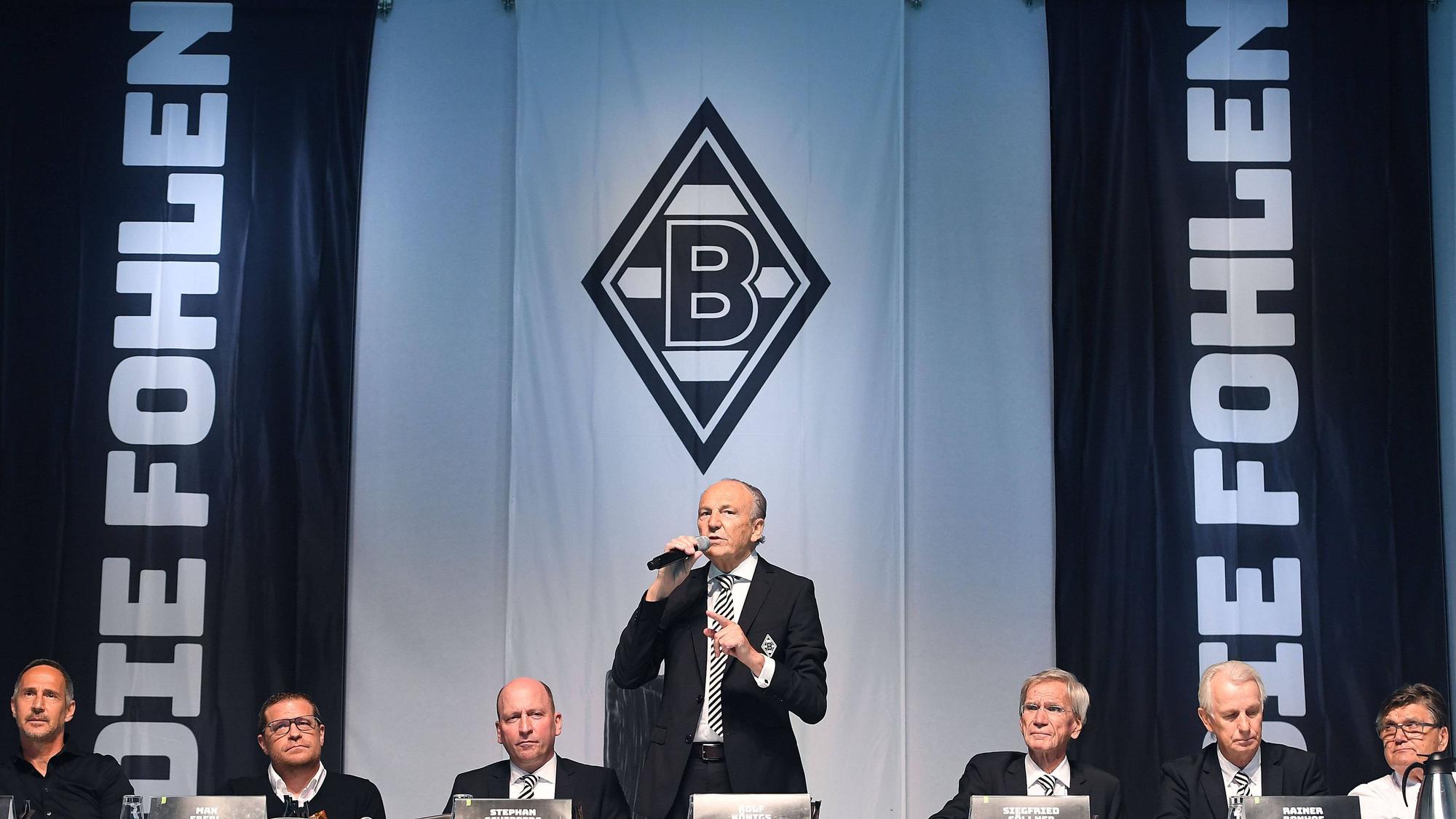 Adi Hütter, Max Eberl, Stephan Schippers, Rolf Königs, Siegfried Söllner, Rainer Bonhof, Hans Meyer (v.l.n.r.) bei der Mitgliederversammlung von Fußball-Bundesligist Borussia Mönchengladbach am 10. August 2021 im Borussia-Park. Präsident Königs spricht per Mikro Richtung Zuschauer.