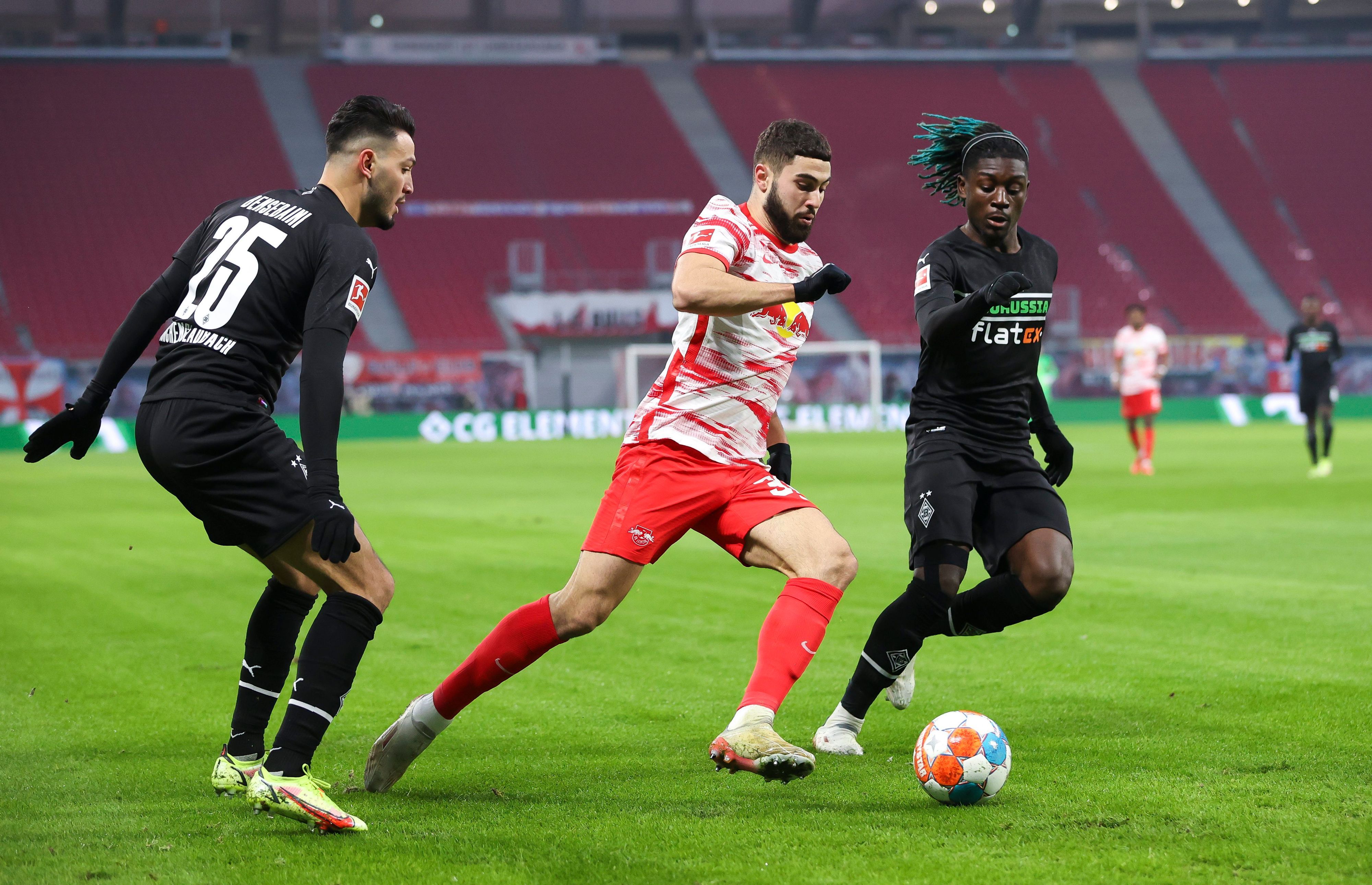 11.12.2021, Sachsen, Leipzig: Fußball: Bundesliga, 15. Spieltag, RB Leipzig - Borussia Mönchengladbach in der Red-Bull-Arena. Leipzigs Josko Gvardiol (M) im Duell mit Gladbachs Ramy Bensebaini (l) und Manu Koné.