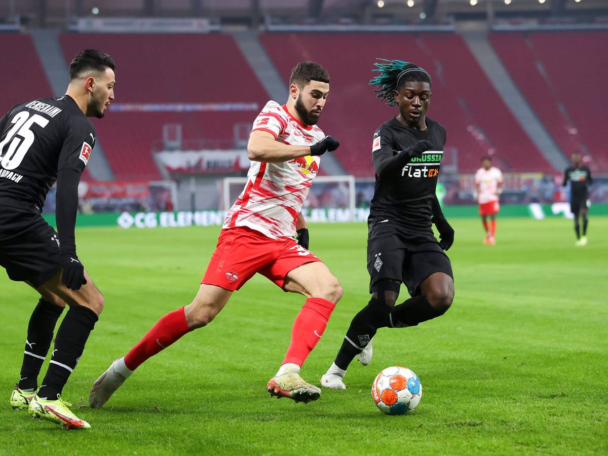 11.12.2021, Sachsen, Leipzig: Fußball: Bundesliga, 15. Spieltag, RB Leipzig - Borussia Mönchengladbach in der Red-Bull-Arena. Leipzigs Josko Gvardiol (M) im Duell mit Gladbachs Ramy Bensebaini (l) und Manu Koné.