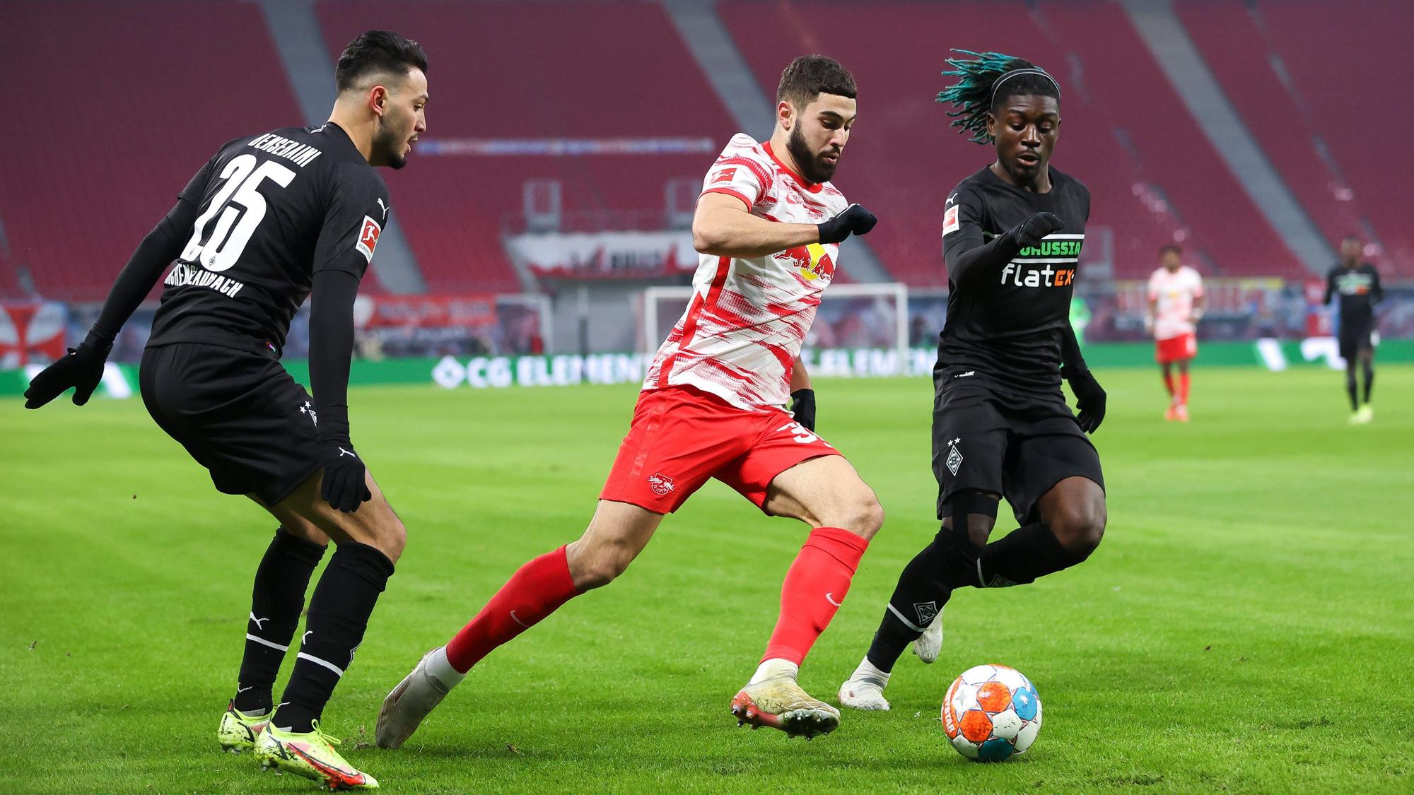 11.12.2021, Sachsen, Leipzig: Fußball: Bundesliga, 15. Spieltag, RB Leipzig - Borussia Mönchengladbach in der Red-Bull-Arena. Leipzigs Josko Gvardiol (M) im Duell mit Gladbachs Ramy Bensebaini (l) und Manu Koné.