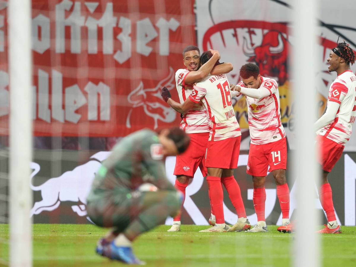 Gladbach-Torhüter Yann Sommer am Boden, derweil jubeln die Spieler von RB Leipzig über einen Treffer im Bundesliga-Duell am 11. Dezember 2021. Ein Foto mit Symbolcharakter für die sportliche Krise der Fohlen-Elf in diesen Tagen. Sommer blickt in der Hocke niedergeschlagen auf den Boden.Trag