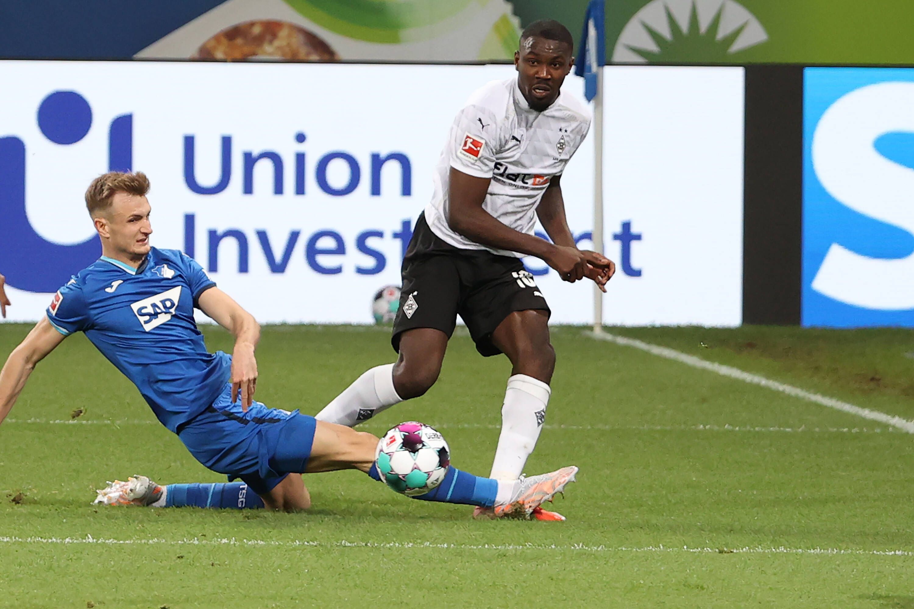 Stefan Posch (l.) von der TSG Hoffenheim klärt einen Ball von Marcus Thuram (r.), Borussia Mönchengladbach, am 21. April 2021 im Bundesligaduell der beiden Teams.
