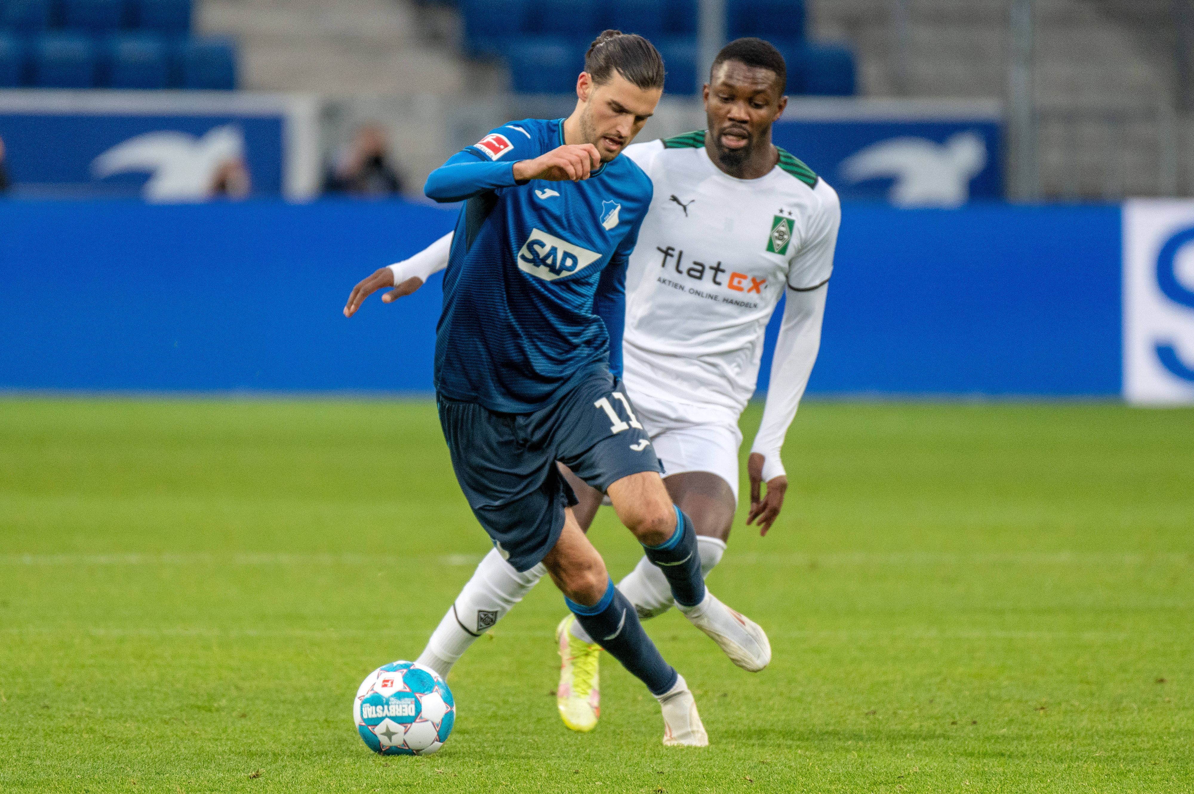 Florian Grillitsch (l.) von der  TSG 1899 Hoffenheim gegen Marcus Thuram (r.) von Borussia Mnchengladbach am 18. Dezember 2021.