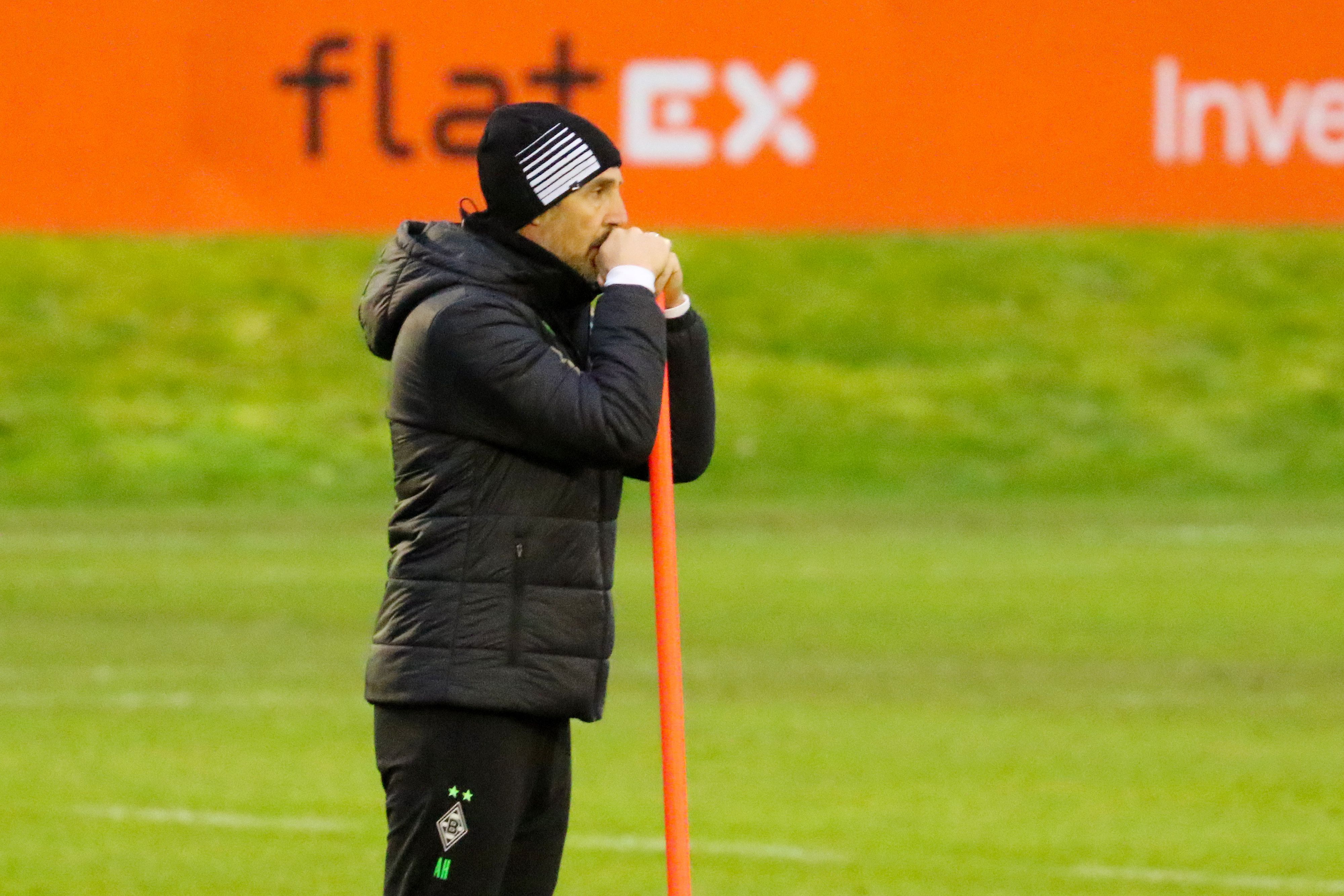 Adi Hütter, Trainer von Borussia Mönchengladbach lehnt auf einem orangenen Stab beim Training am Borussia-Park am 13. Dezember 2021.