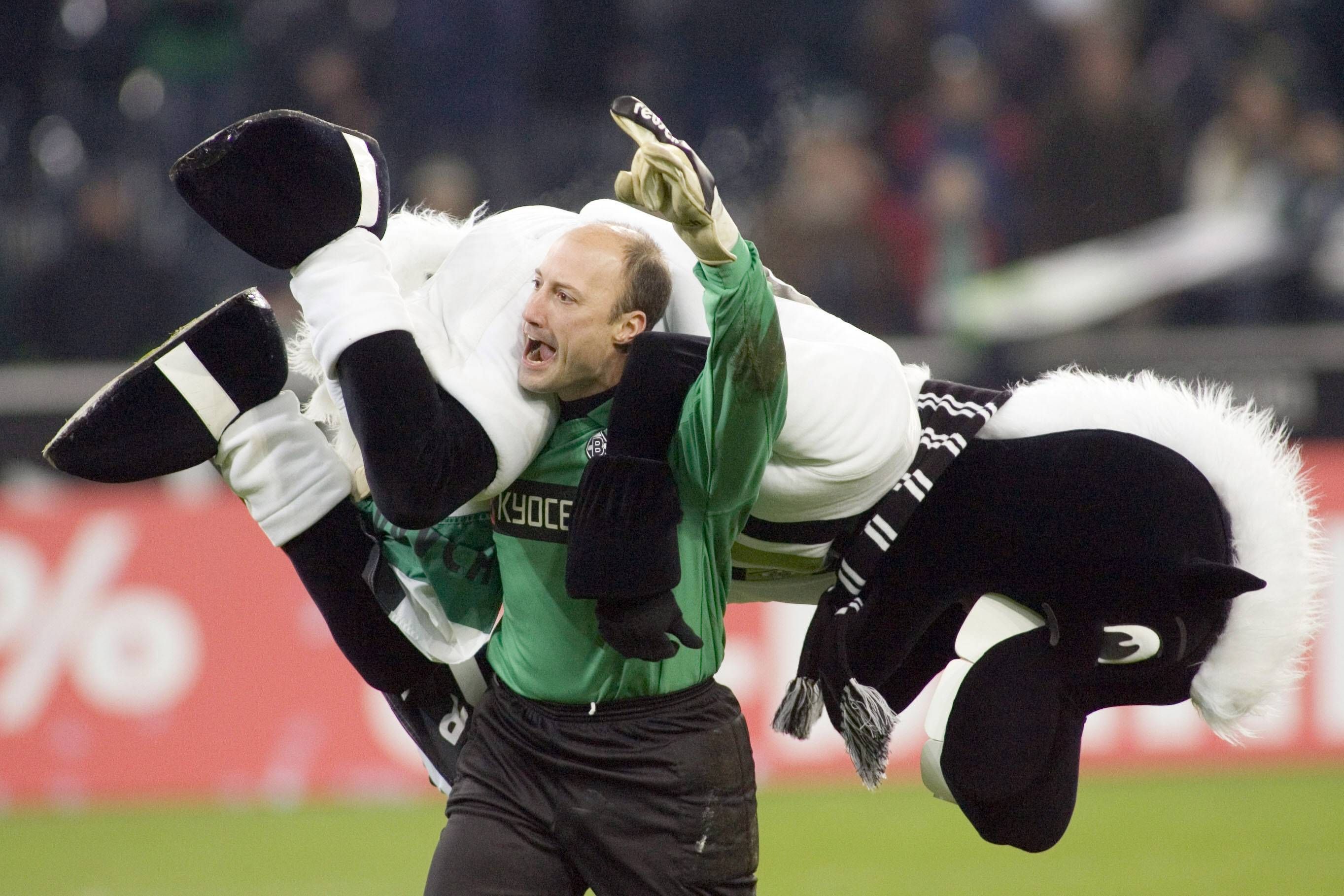 Kasey Keller, ehemaliger Torhüter von Borussia Mönchengladbach. Auf diesem Foto hat der US-Amerikaner im Borussia-Park Fohlen-Maskottchen Jünter am 17. Dezember 2005 im Stile eines Wrestlers auf die Schulter genommen. Keller jubelt, während er Jünter trägt.