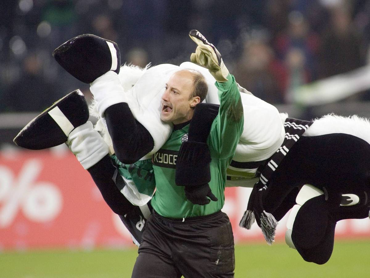Kasey Keller, ehemaliger Torhüter von Borussia Mönchengladbach. Auf diesem Foto hat der US-Amerikaner im Borussia-Park Fohlen-Maskottchen Jünter am 17. Dezember 2005 im Stile eines Wrestlers auf die Schulter genommen. Keller jubelt, während er Jünter trägt.