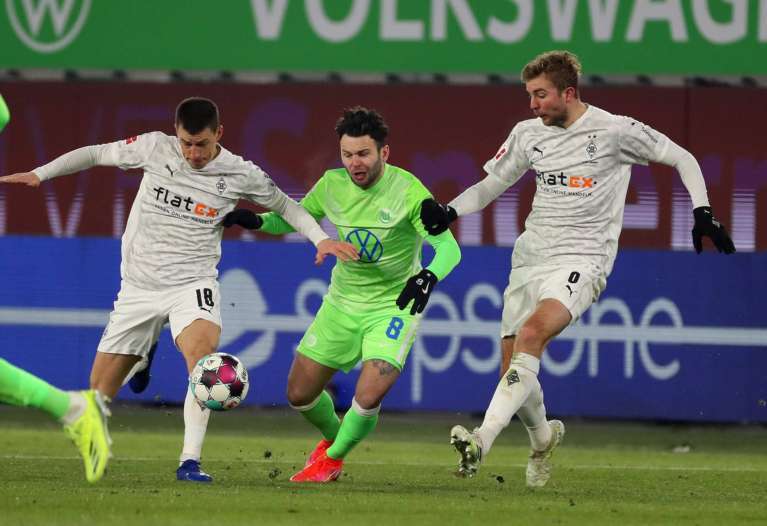 Borussia Mönchengladbach, hier Stefan Lainer (l) und Christoph Kramer (r) im Zweikampf mit Renato Steffen, trennte sich im Sonntagsspiel 0:0 vom VfL Wolfsburg.