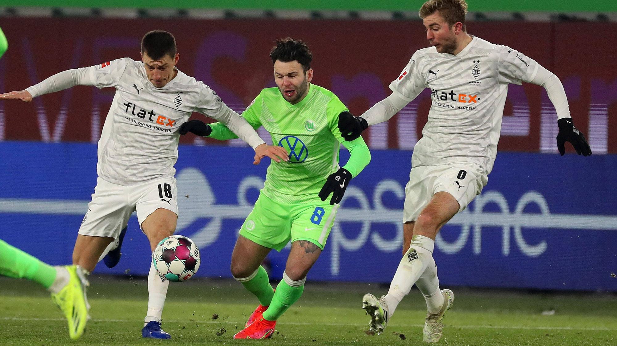 Borussia Mönchengladbach, hier Stefan Lainer (l) und Christoph Kramer (r) im Zweikampf mit Renato Steffen, trennte sich im Sonntagsspiel 0:0 vom VfL Wolfsburg.