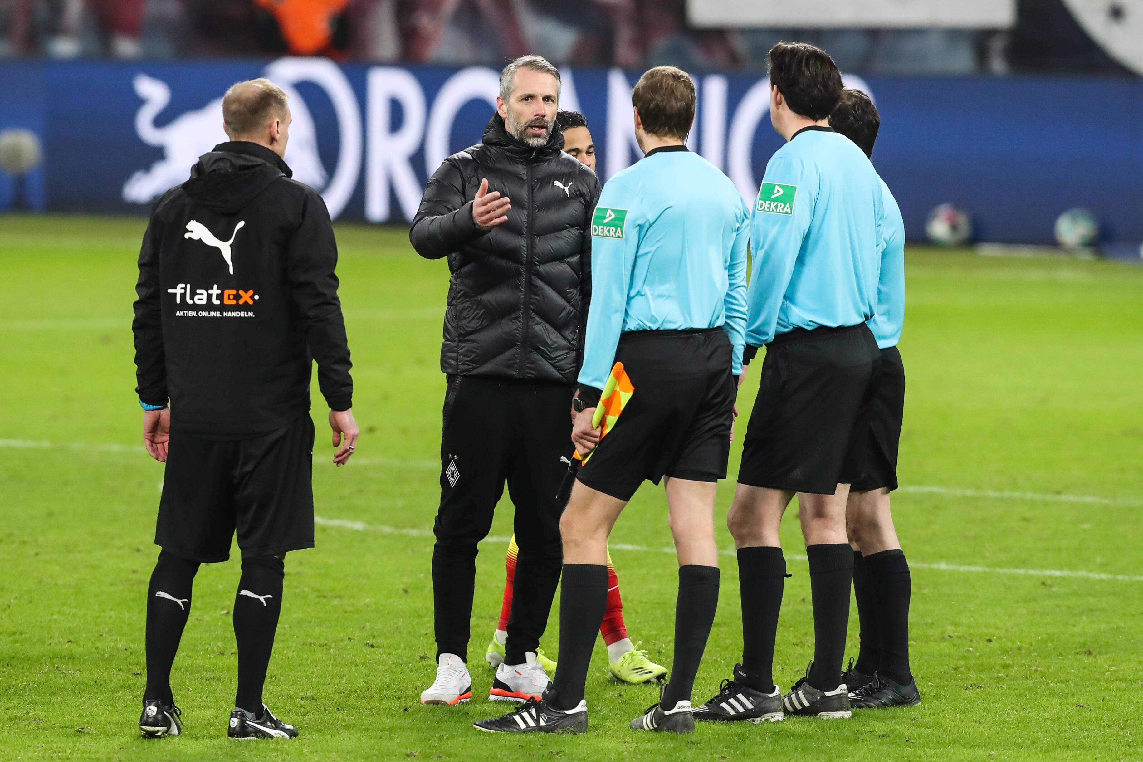 Gladbach-Trainer Marco Rose (M.) diskutiert mit Schiedsrichter Manuel Gräfe nach dem verlorenen Bundesliga-Topspiel (27. Februar 2021) bei RB Leipzig. Rose gestikuliert und spricht. Sein Assistent Alexander Zickler (l.) schaut zu.