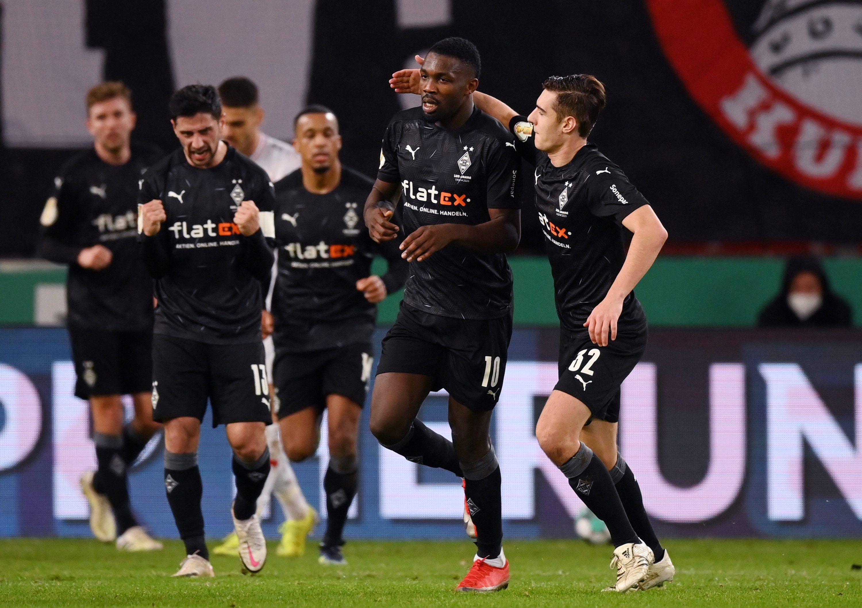 Marcus Thuram (l.) und Florian Neuhaus (r.) bejubeln den Treffer zum 1:1, den Thuram in der Nachspielzeit der ersten Halbzeit im DFB-Pokal-Match beim VfB Stuttgart erzielte.