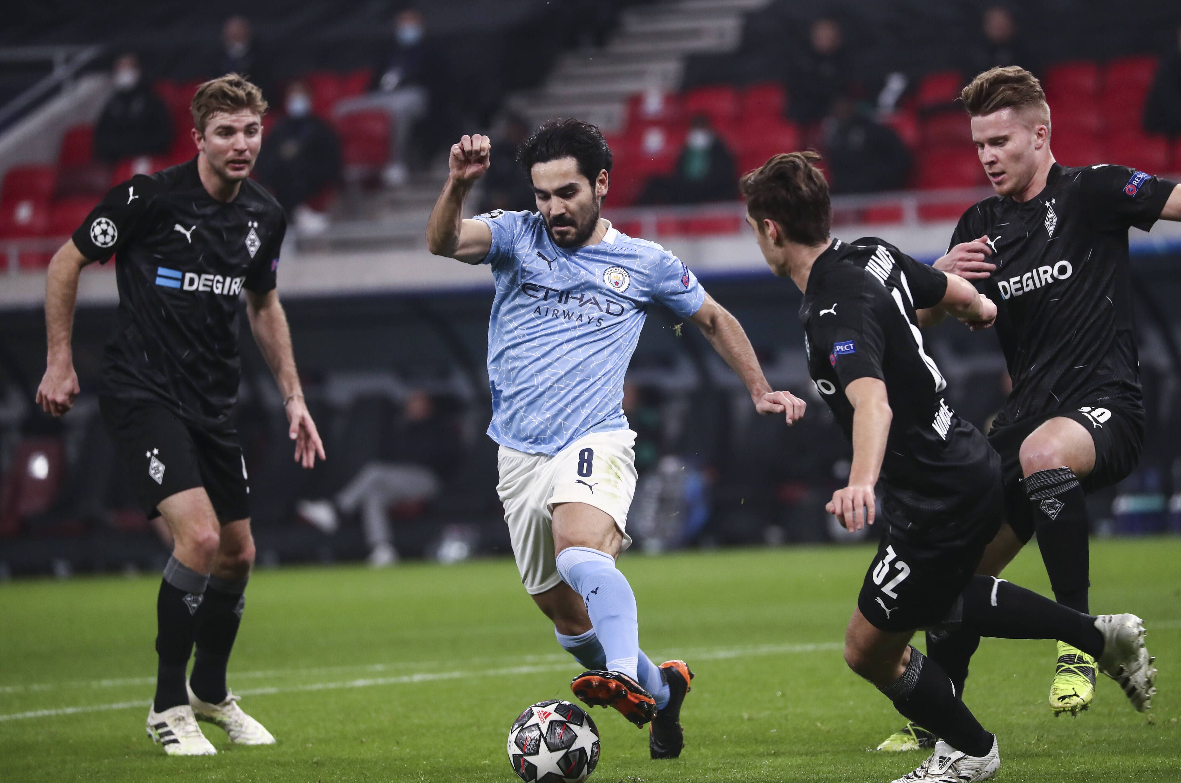 Manchester Citys Ilkay Gündogan im Kampf um den Ball mit den Gladbachern Christoph Kramer (l), Florian Neuhaus und Nico Elvedi, während des Achtelfinal-Hinspiels in der Champions League am 24. Februar 2021.