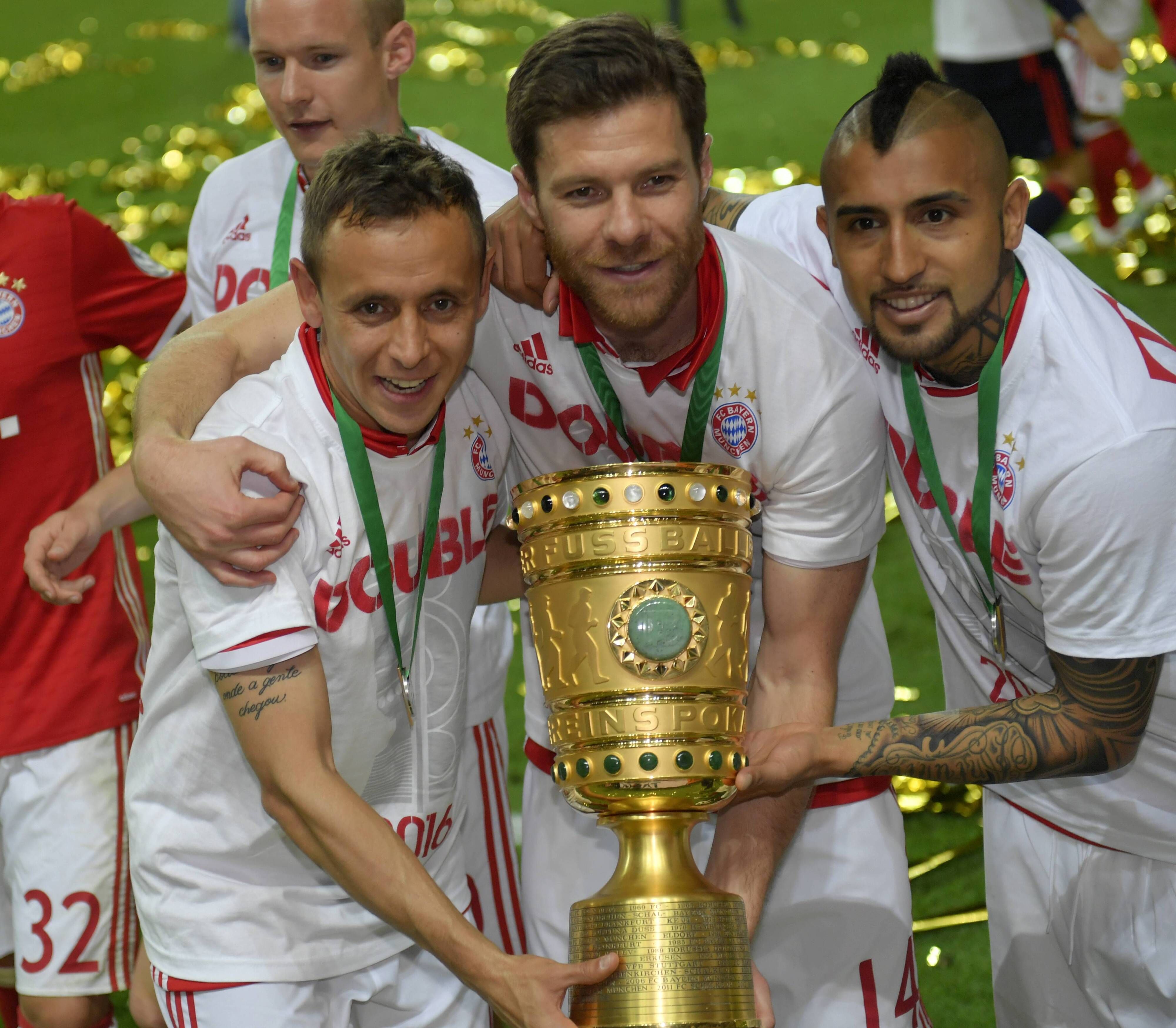 Xabi Alonso in der Mitte mit Rafinha (l.) und Arturo Vidal (r.) zeigen den DFB-Pokal nach dem Pokalfinale der Bayern gegen den BVB im Berliner Olympiastadion am 21. Mai 2016.