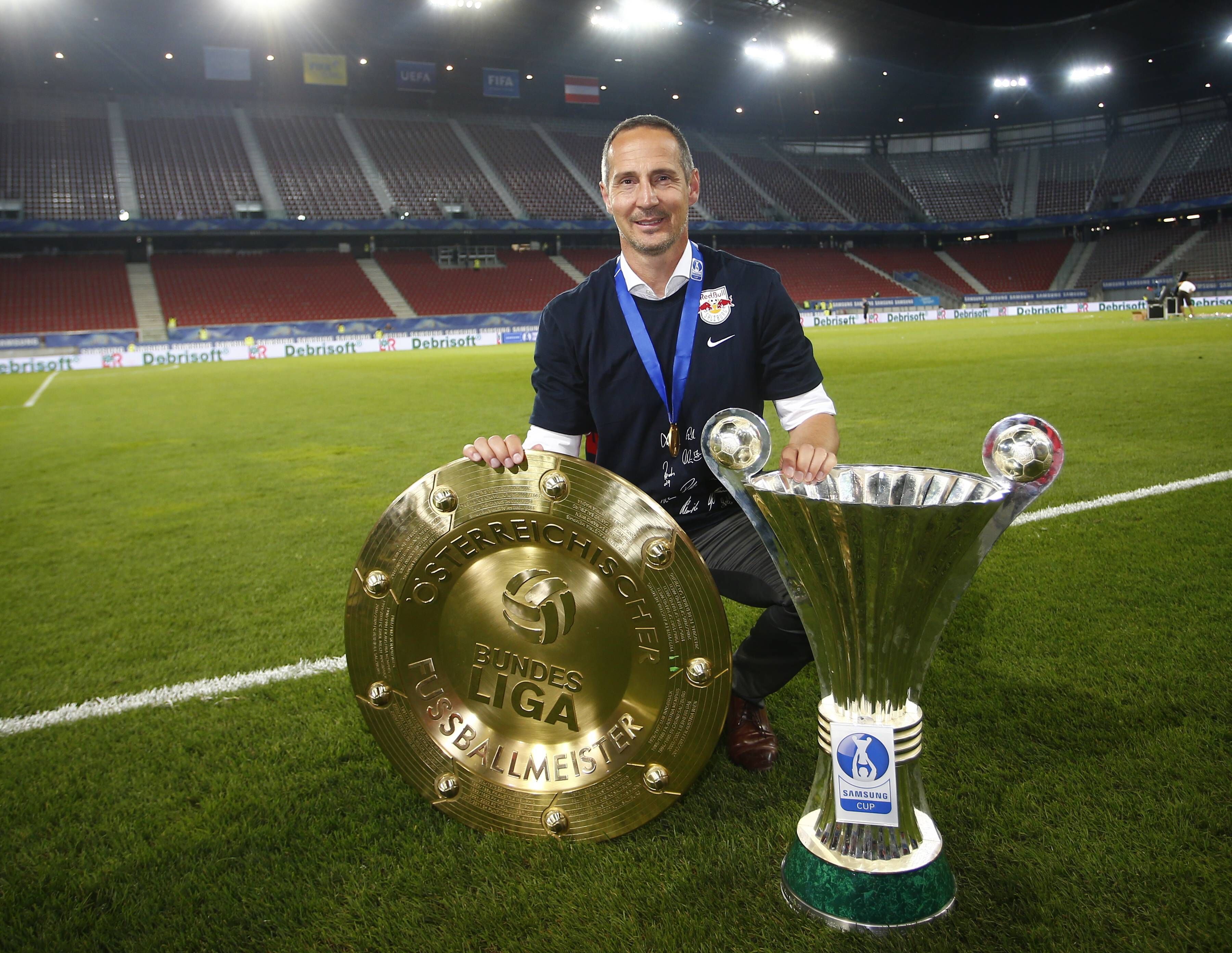 Adi Hütter posiert am 3. Juni 2015 mit der Meisterschale und dem Pokal, die er mit dem FC Red Bull Salzburg 2015 geholt hat.