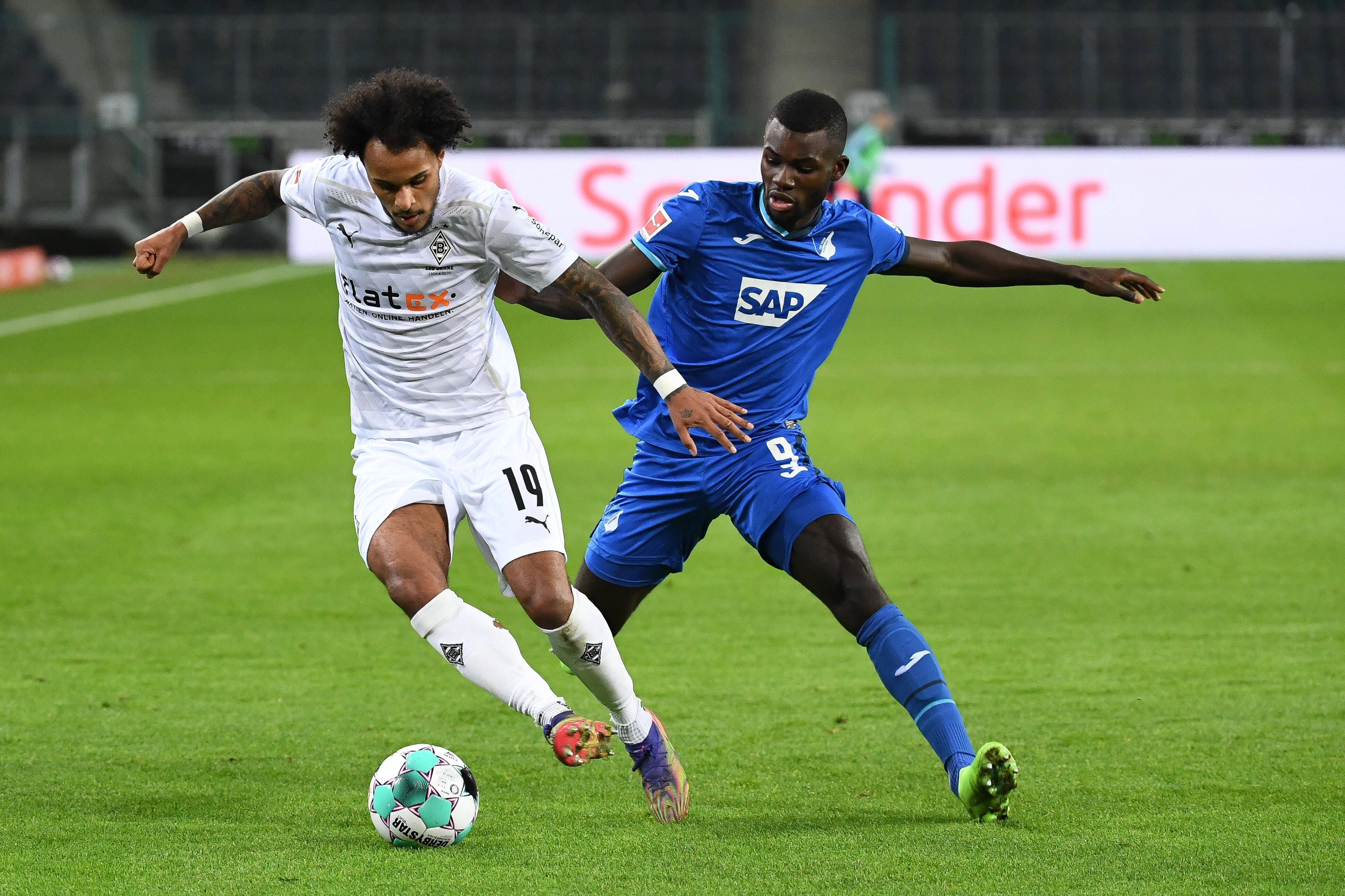 Gladbachs Valentino Lazaro (l.) behauptet den Ball gegen Ihlas Bebou (r.) im Bundesligaspiel der Gladbacher gegen die TSG Hoffenheim am 19. Dezember 2020 im Borussia-Park.