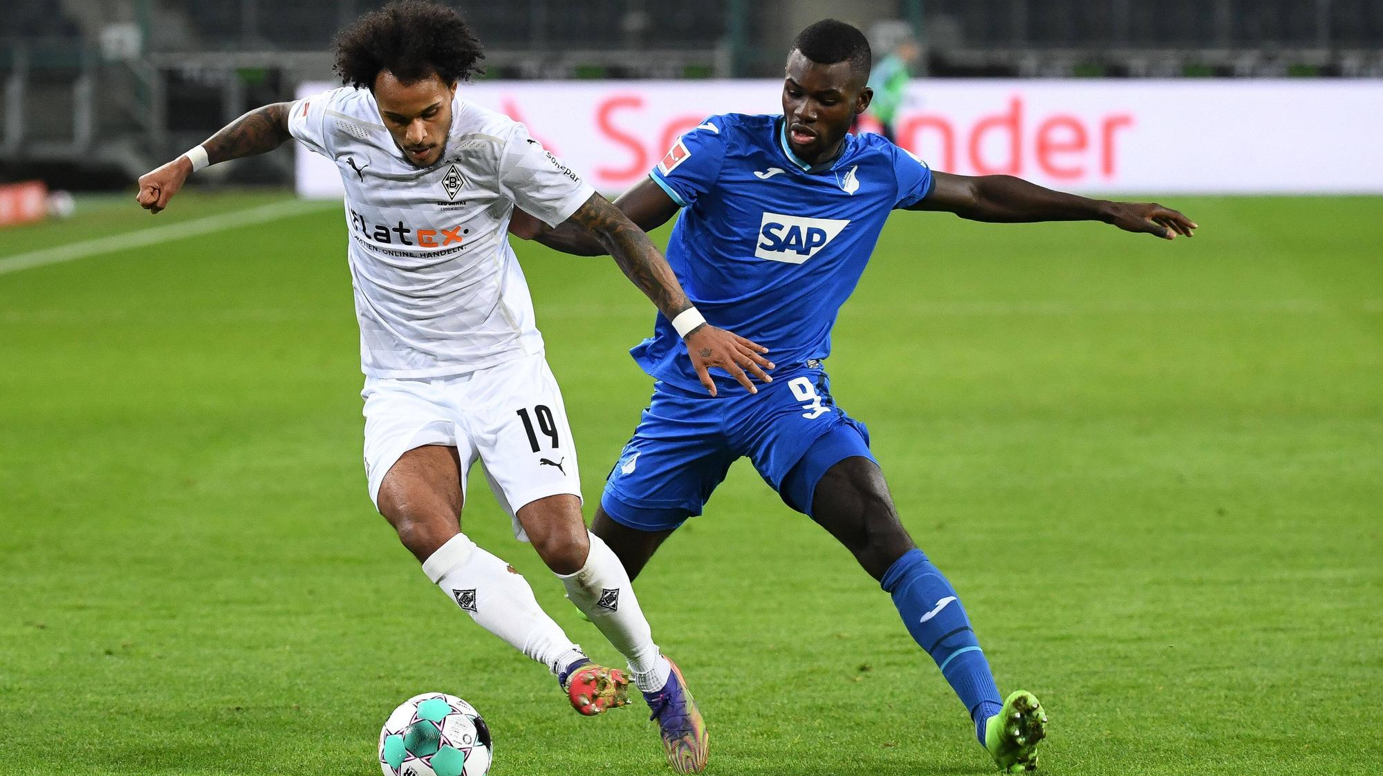 Gladbachs Valentino Lazaro (l.) behauptet den Ball gegen Ihlas Bebou (r.) im Bundesligaspiel der Gladbacher gegen die TSG Hoffenheim am 19. Dezember 2020 im Borussia-Park.