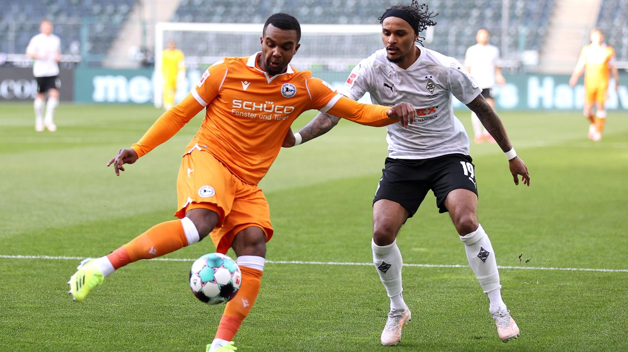 Gladbachs Valentino Lazaro (r.) kämpft gegen Nathan de Medina (l.) um den Ball im Bundesligaspiel der Borussia gegen Arminia Bielefeld am 25. April 2021.
