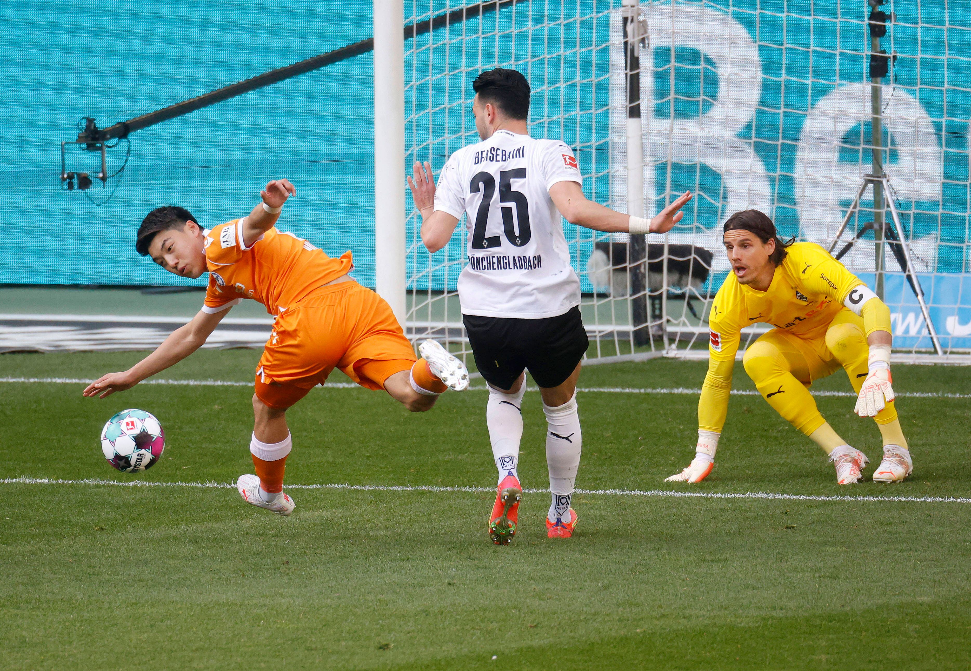Torhüter Yann Sommer (r.) von Borussia Mönchengladbach schaut im Bundesligaspiel gegen Arminia Bielfeld am 25. April 2021 genau zu beim Zweikampf zwischen Rami Bensebaini (M.) und Ritsu Doan (l.).