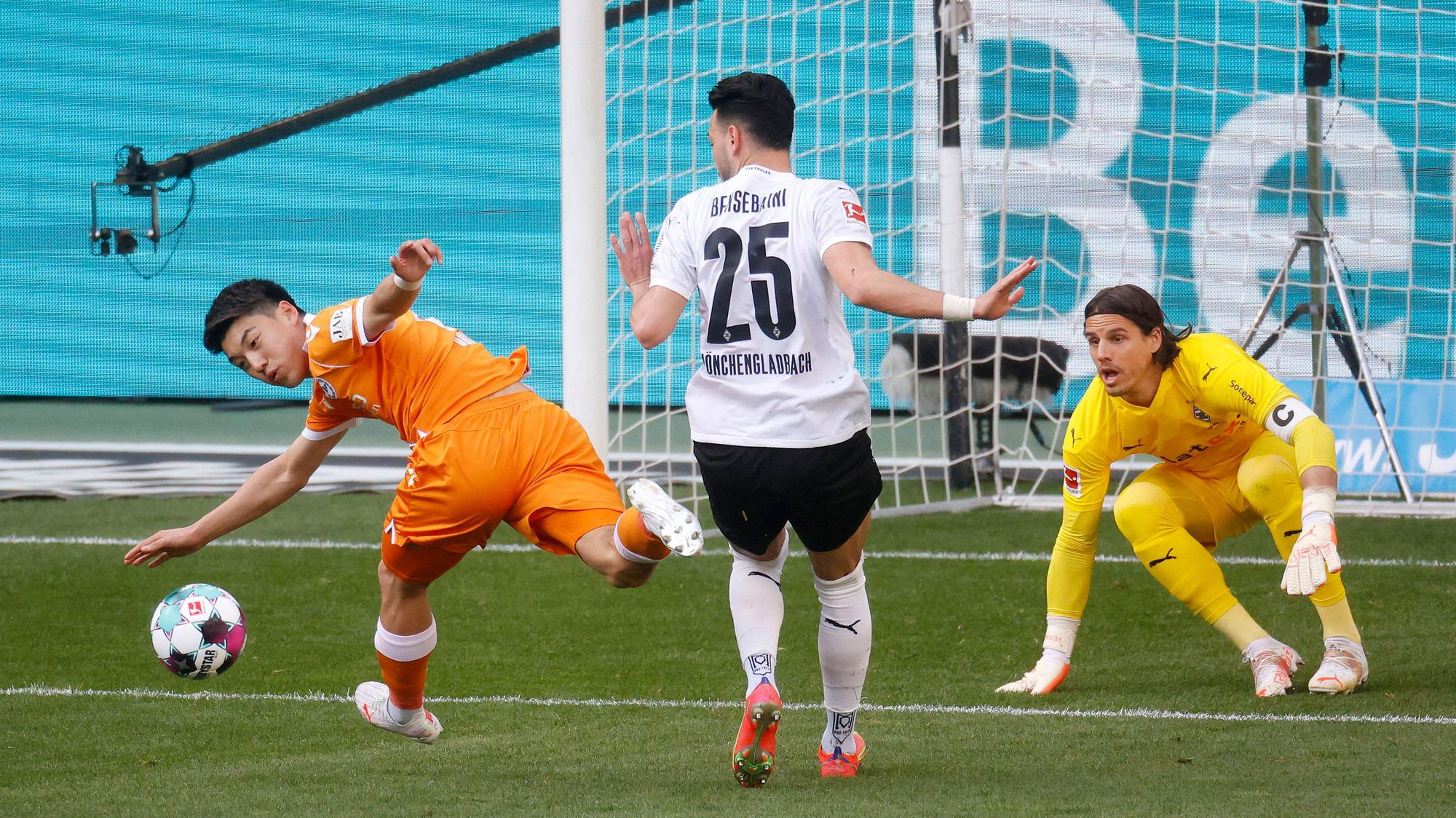 Torhüter Yann Sommer (r.) von Borussia Mönchengladbach schaut im Bundesligaspiel gegen Arminia Bielfeld am 25. April 2021 genau zu beim Zweikampf zwischen Rami Bensebaini (M.) und Ritsu Doan (l.).