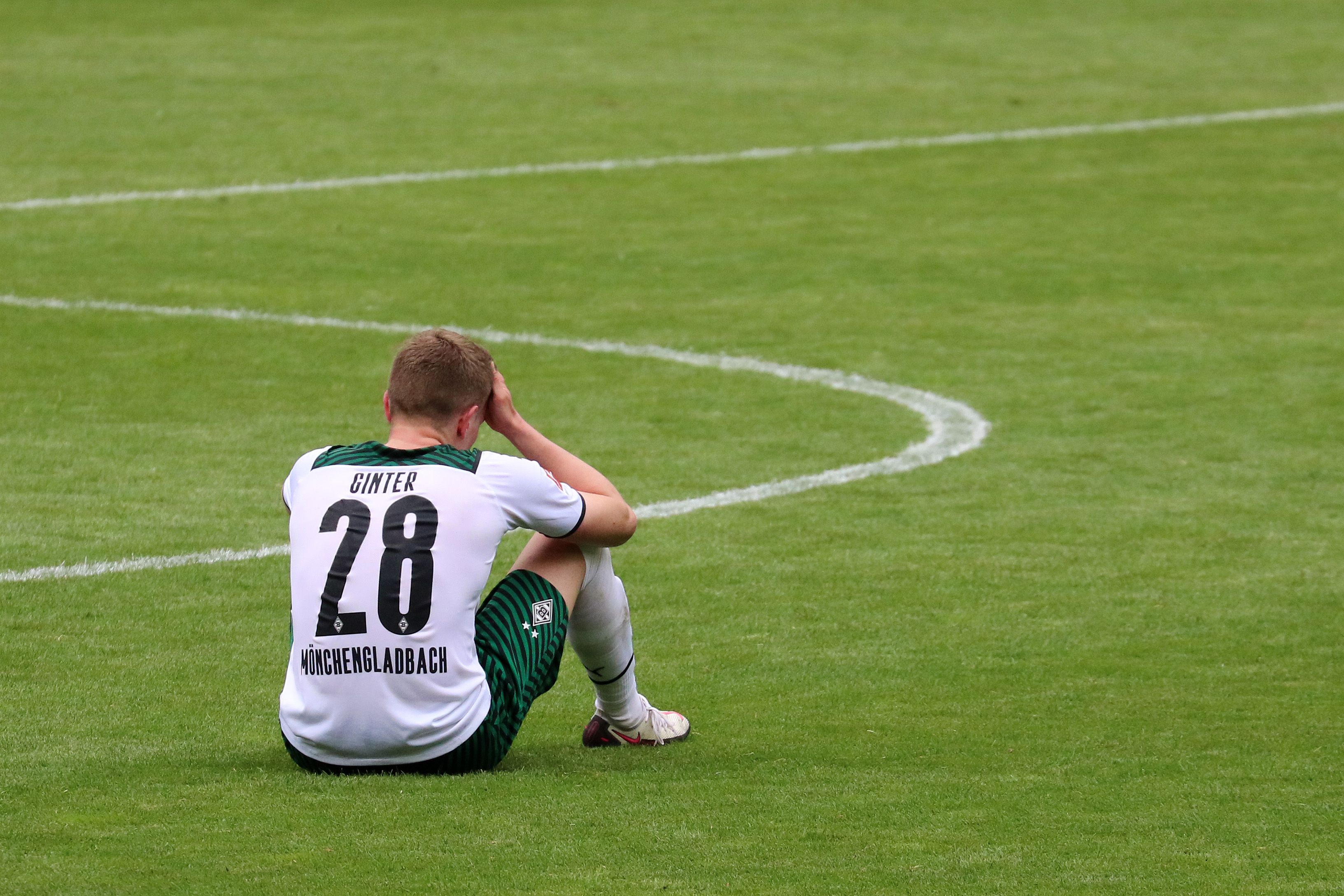 Gladbachs Matthias Ginter sitzt nach dem 1:2 gegen Stuttgart am 15. Mai 2021 enttäuscht auf dem Rasen im Borussia-Park.