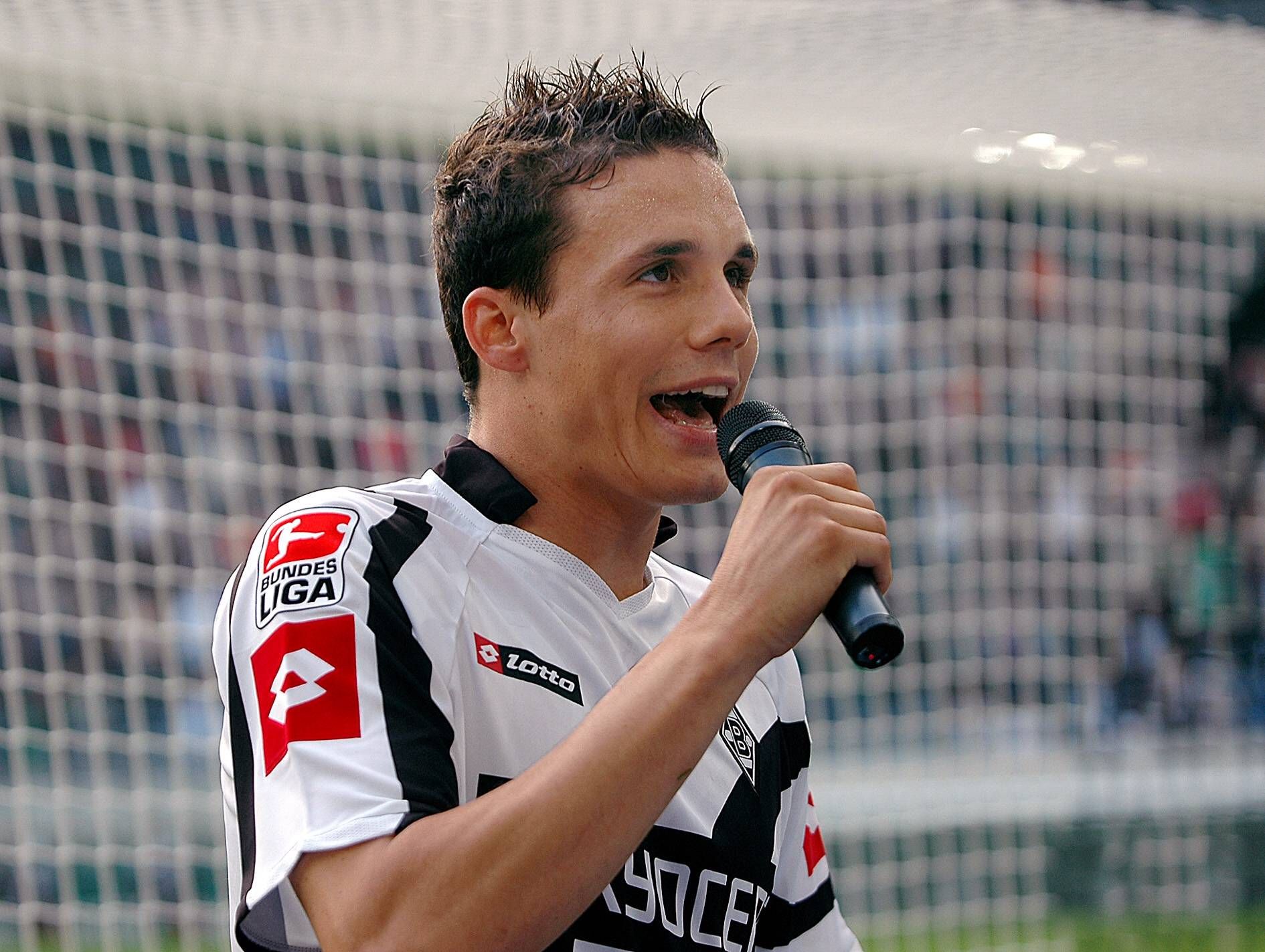 David Degen im Trikot der Gladbacher Borussia. Dieses Foto entstand am 14. Oktober 2006 und zeigt Degen vor der Nordkurve im Borussia-Park mit dem Stadionmikro in der Hand.