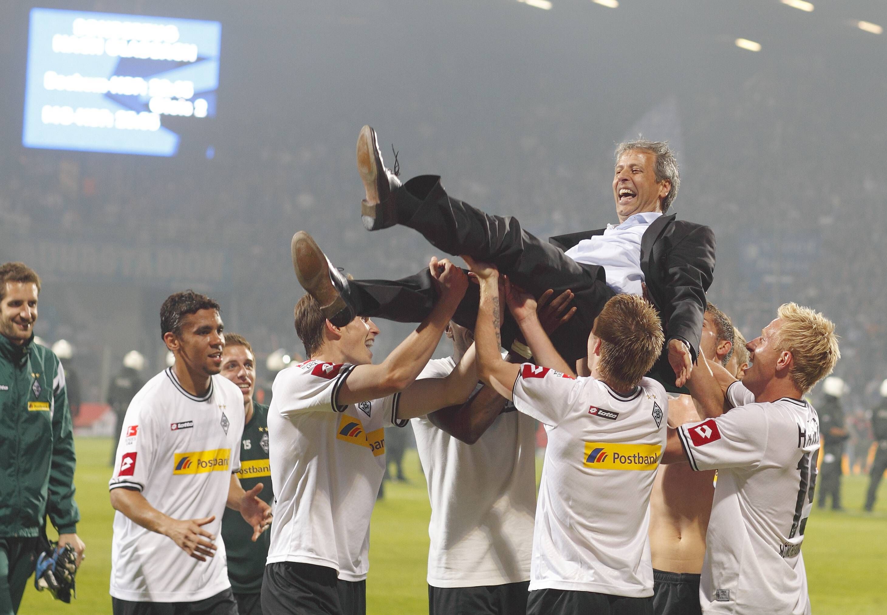 Ex-Gladbach Trainer Lucien Favre wird von den Spielern auf Händen getragen nach dem Rückspiel der Relegation gegen den VfL Bochum am 25. Mai 2011.