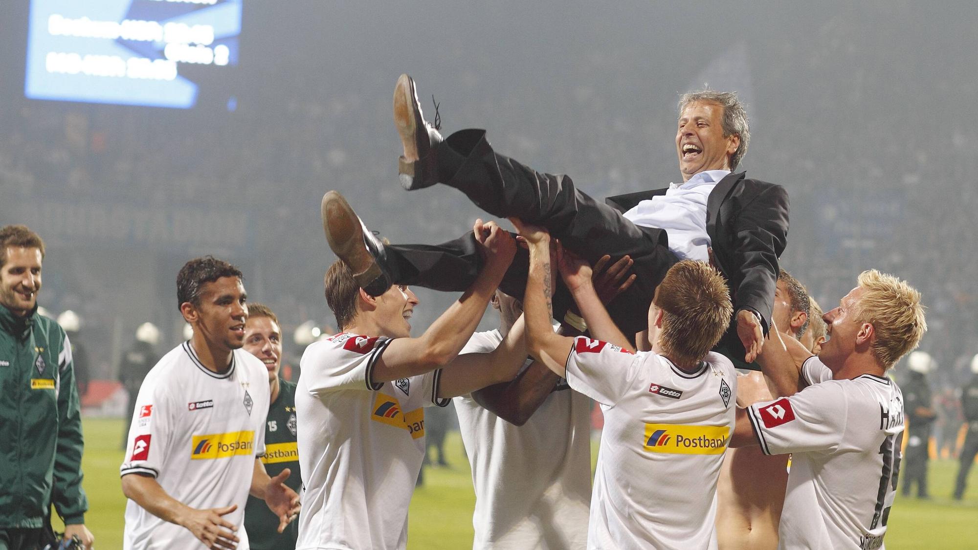 Ex-Gladbach Trainer Lucien Favre wird von den Spielern auf Händen getragen nach dem Rückspiel der Relegation gegen den VfL Bochum am 25. Mai 2011.