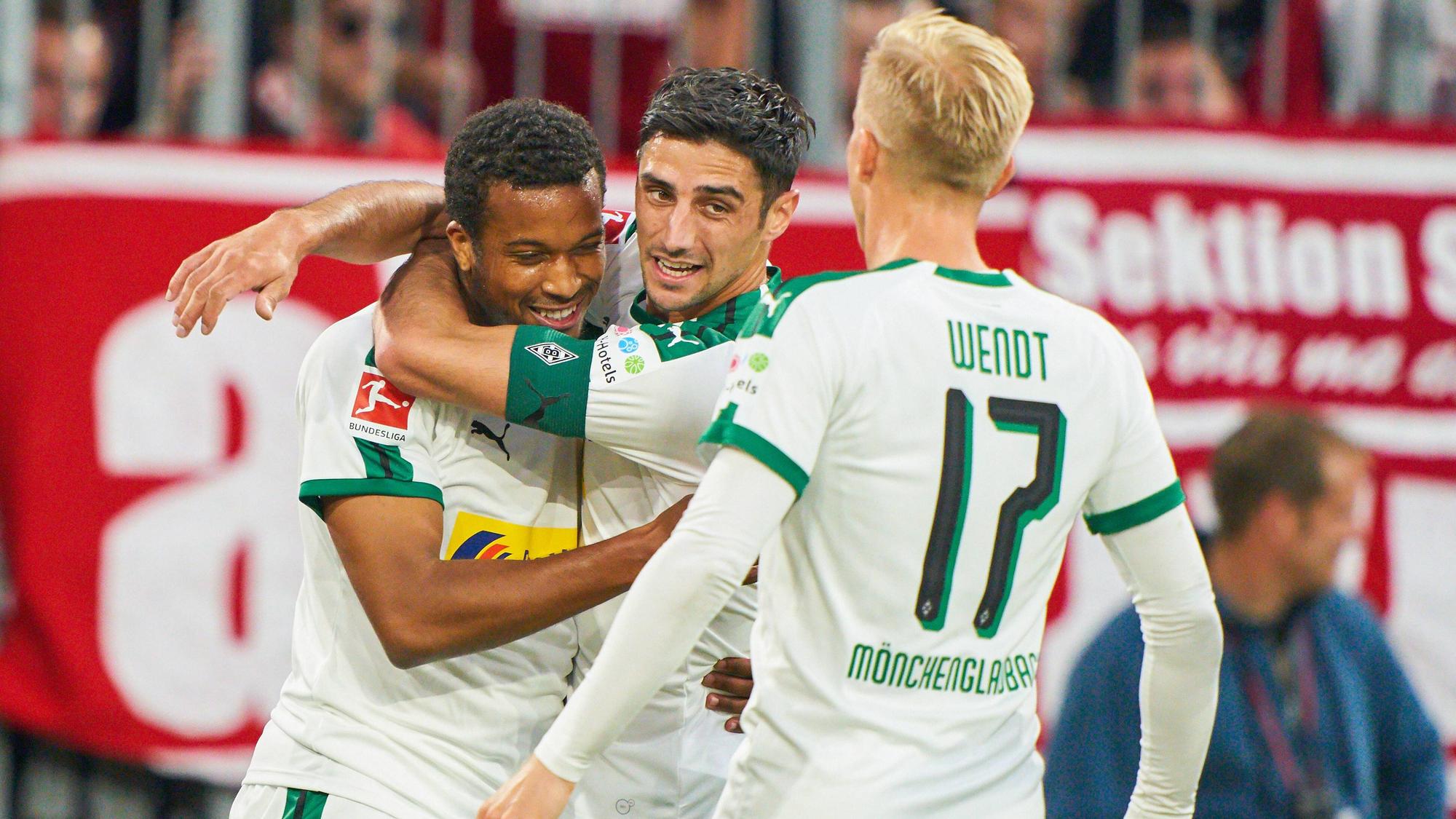 Gladbach-Stürmer Alassane Plea (l.) bejubelt gemeinsam Kapitän Lars Stindl (M.) und Oscar Wendt (r.) seinen herrlichen Treffer beim FC Bayern München am 6. Oktober 2018.