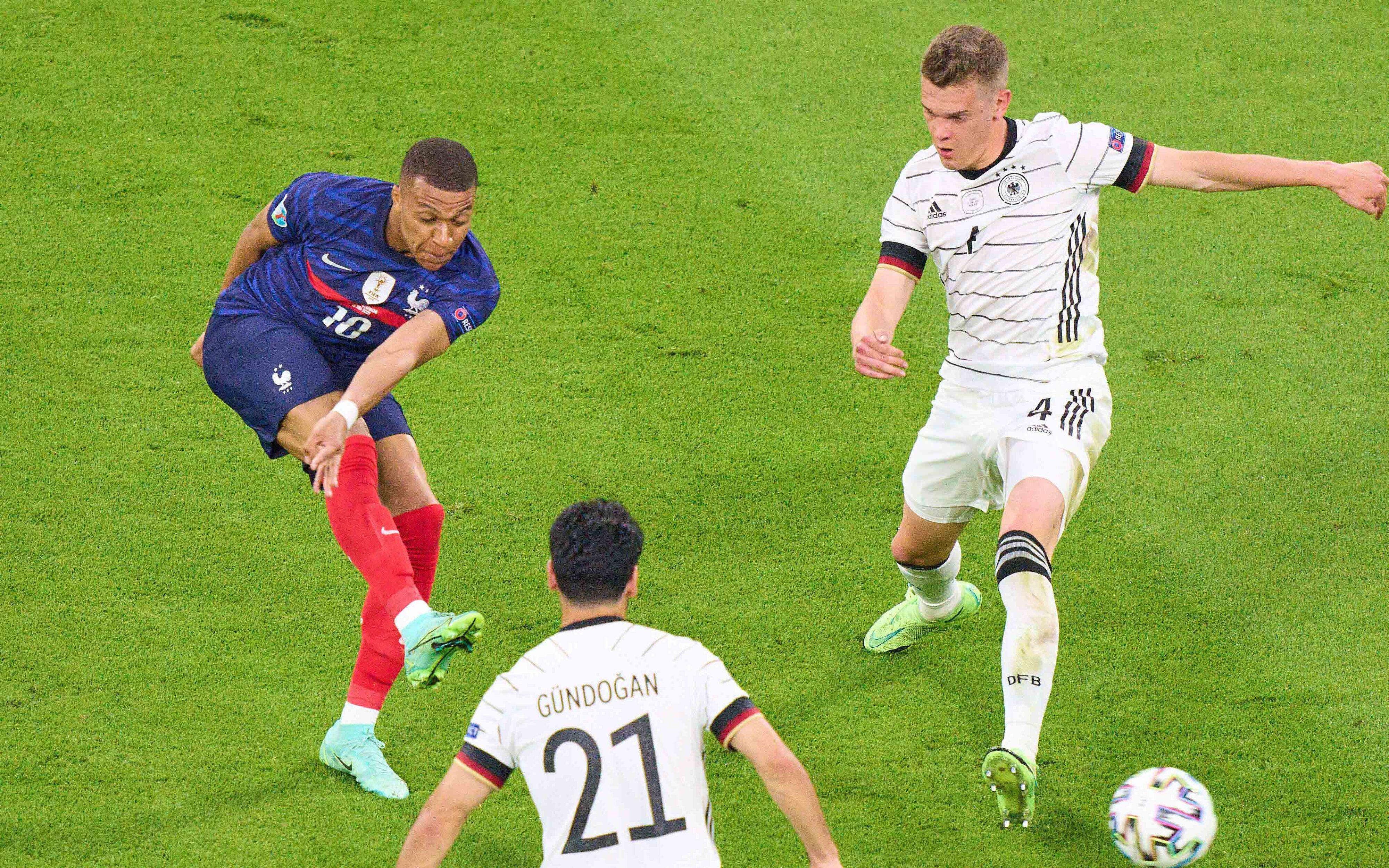 Gladbachs Nationalspieler Matthias Ginter (r.) am 15. Juni 2021 im Zweikampf mit Frankreichs Top-Stürmer Kylian Mbappé (l.). Im Vordergrund schaut DFB-Mittelfeldspieler İlkay Gündoğan zu.