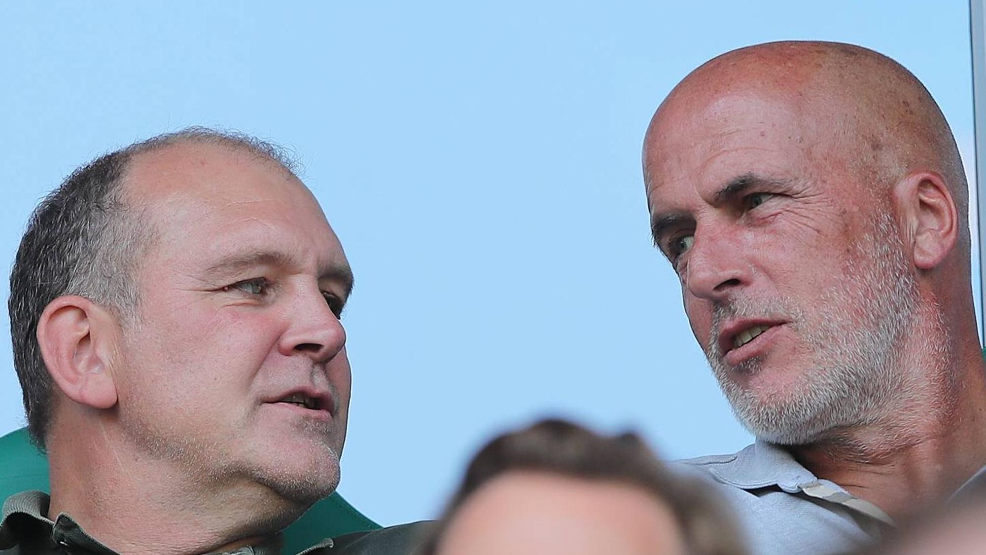Der ehemalige Gladbacher Cheftrainer Michael Frontzeck (r.) und Wolfsburg-Manager Jörg Schmadtke (l.) sitzen am 31. August 2019 gemeinsam auf der Tribüne der Volkswagen-Arena und schauen sich in der Autostadt das Duell gegen den SC Paderborn an.