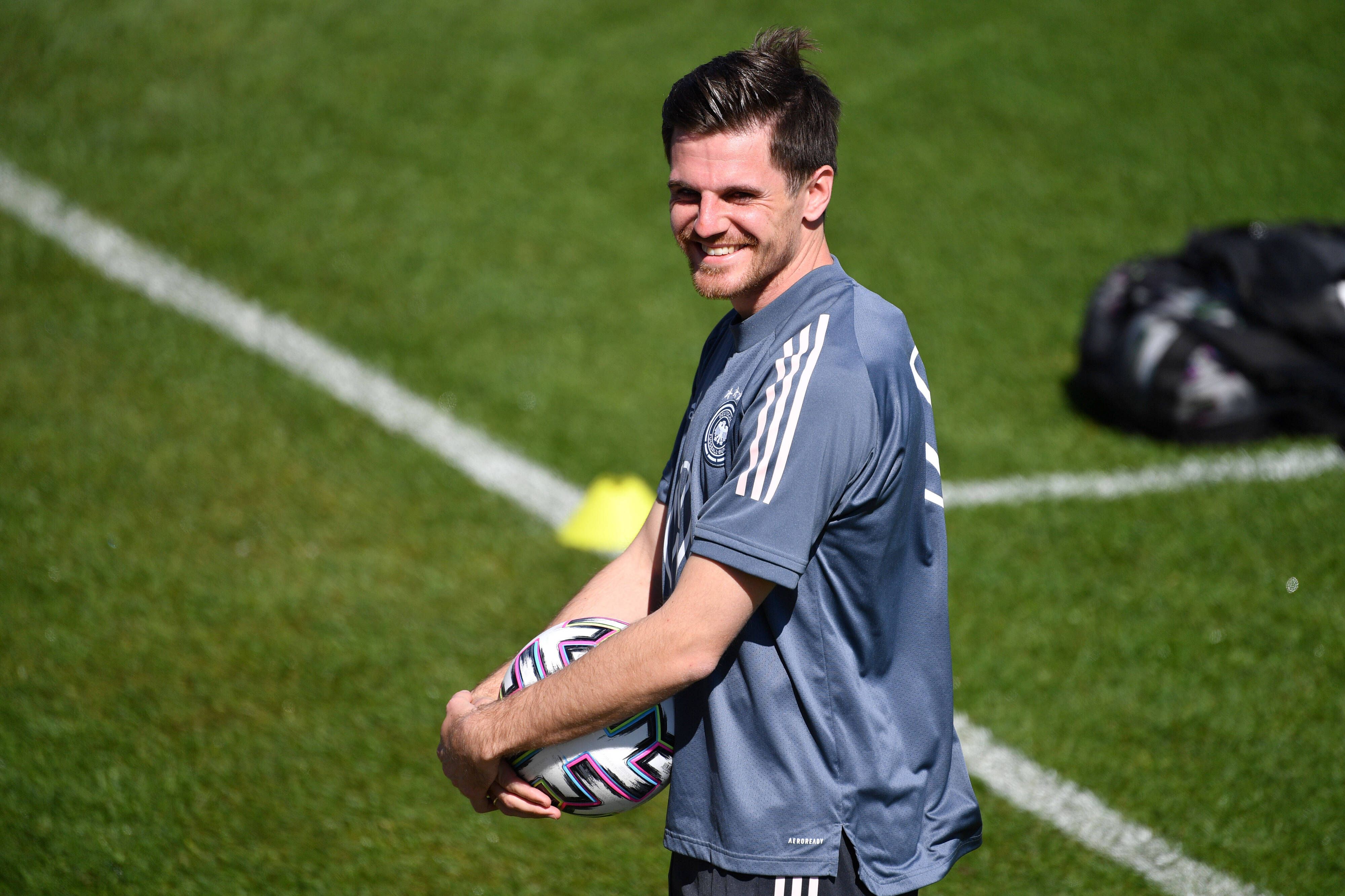 Nationalspieler Jonas Hofmann lächelt, derweil hält er einen Ball in seinen Händen.