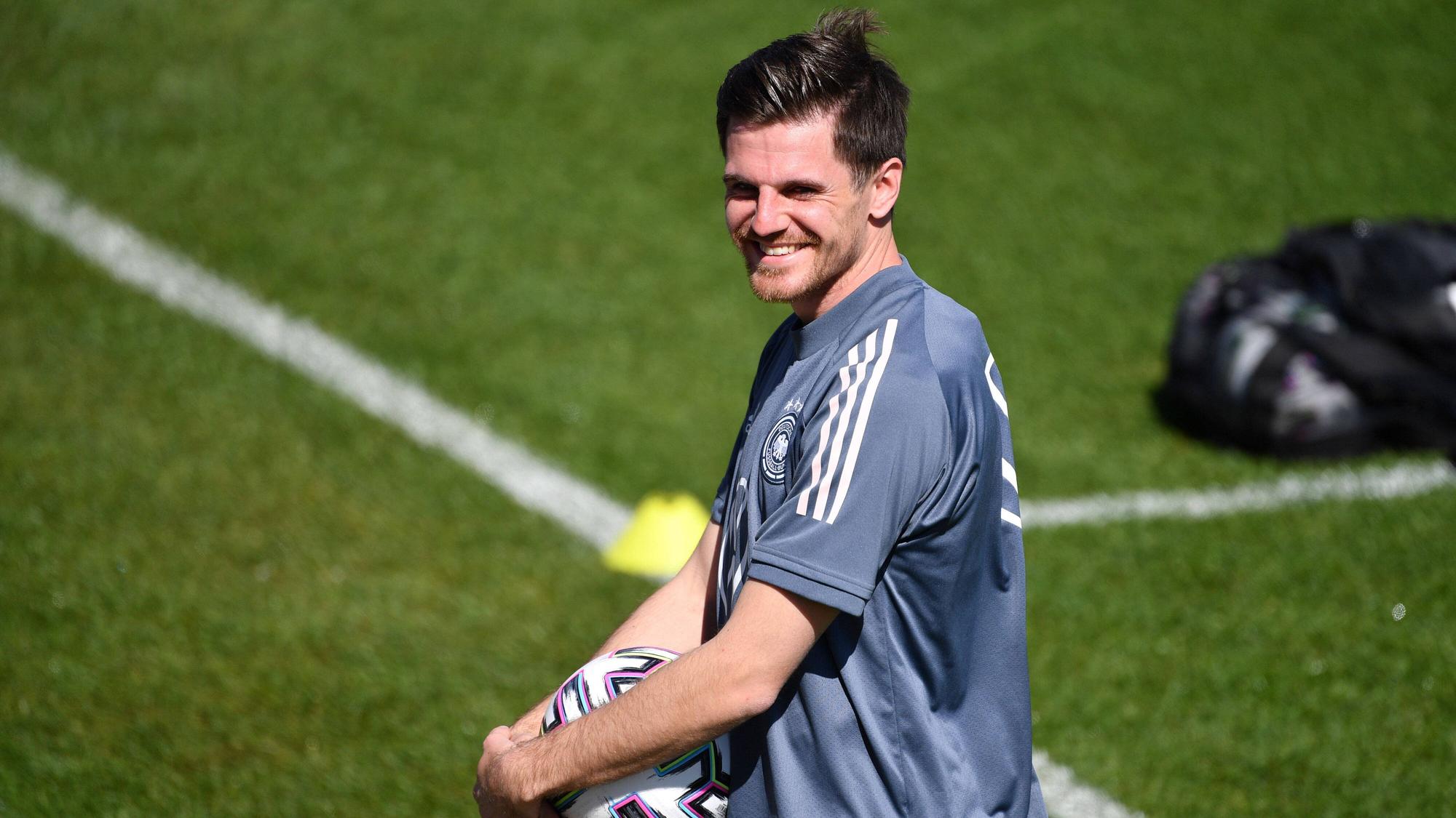 Nationalspieler Jonas Hofmann lächelt, derweil hält er einen Ball in seinen Händen.