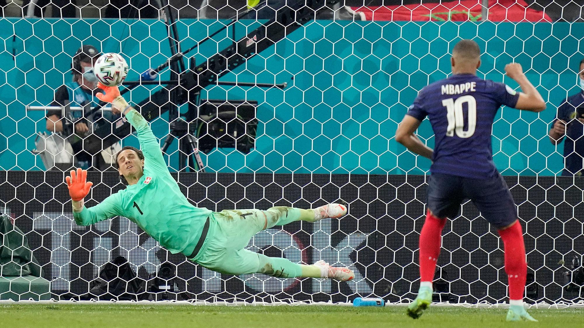 Der Schweizer Yann Sommer hält bei der Fußball-Europameisterschaft im Elfmeterschießen den Schuss von Frankreichs Kylian Mbappe.