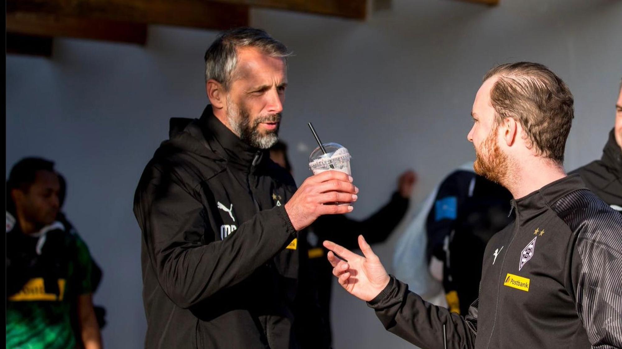 Trainer Marco Rose von Borussia Mönchengladbach bekommt nach dem Training von Melf Carstensen einen Shake gereicht.