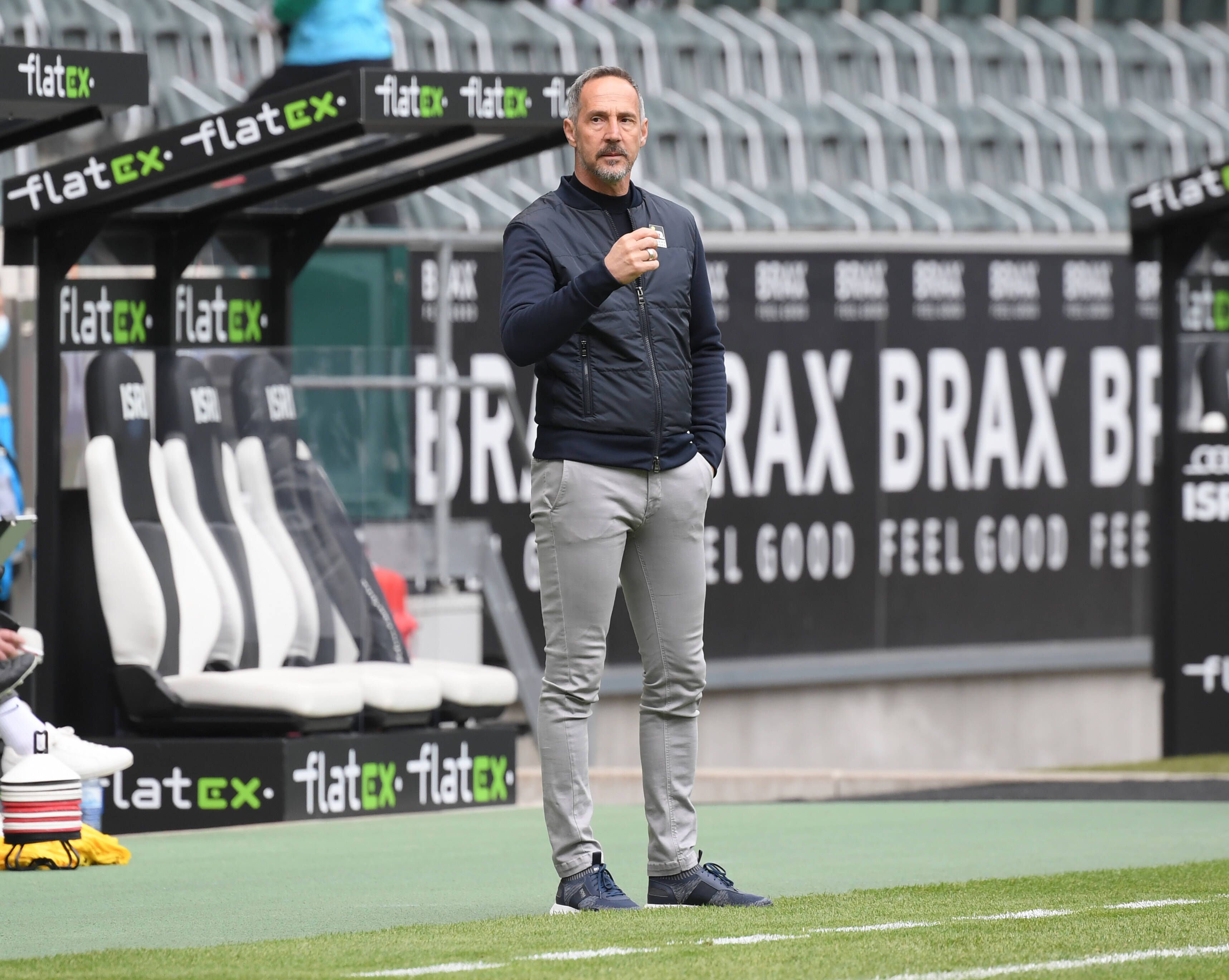 Trainer Adi Hütter steht an der Seitenlinie des Borussia-Parks und blickt auf das Spielfeld.