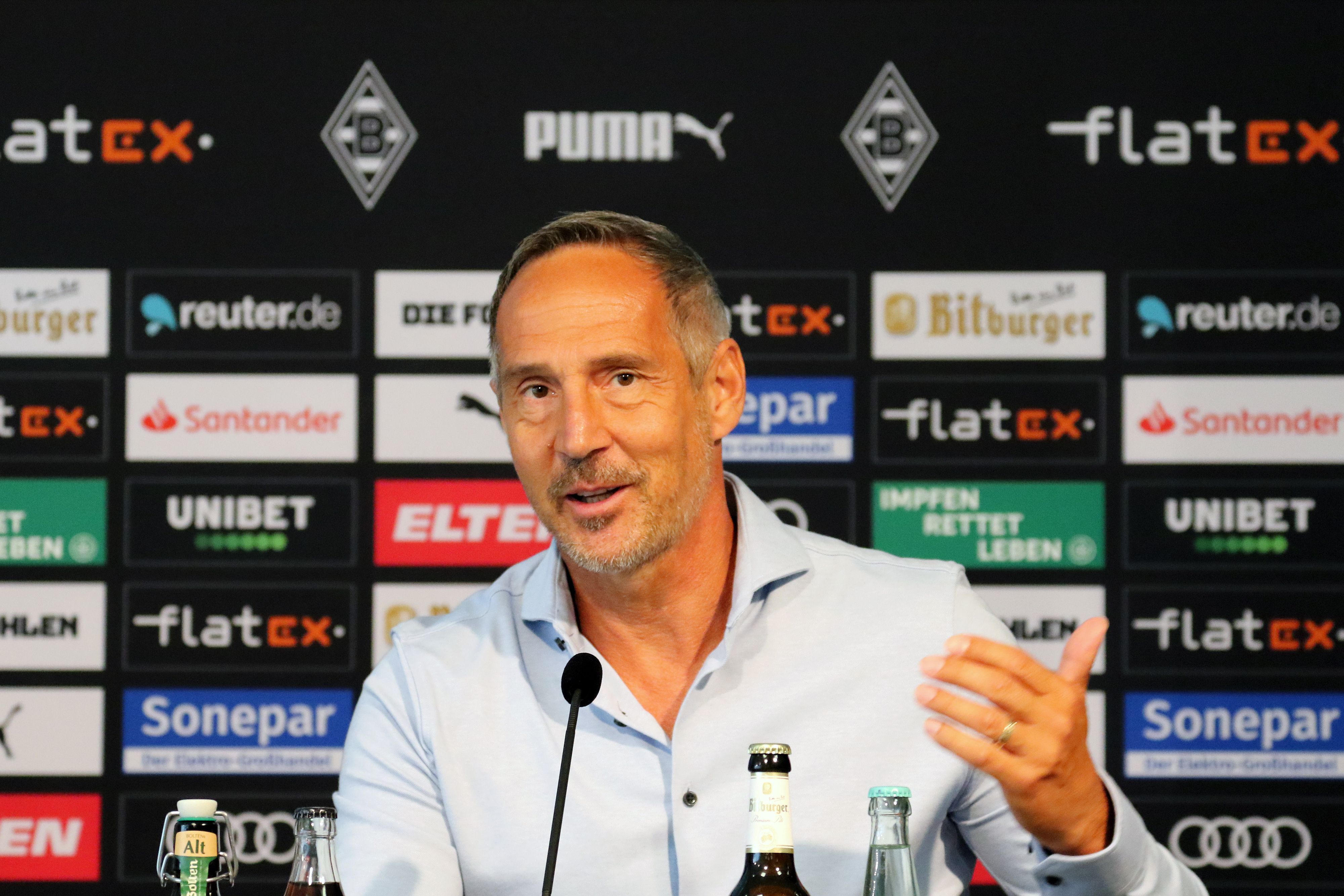 Ex-Gladbach-Trainer Adi Hütter, hier zu sehen am 2. Juli 2021 bei seiner Vorstellung im Borussia-Park. Hütter macht eine Geste und lächelt.