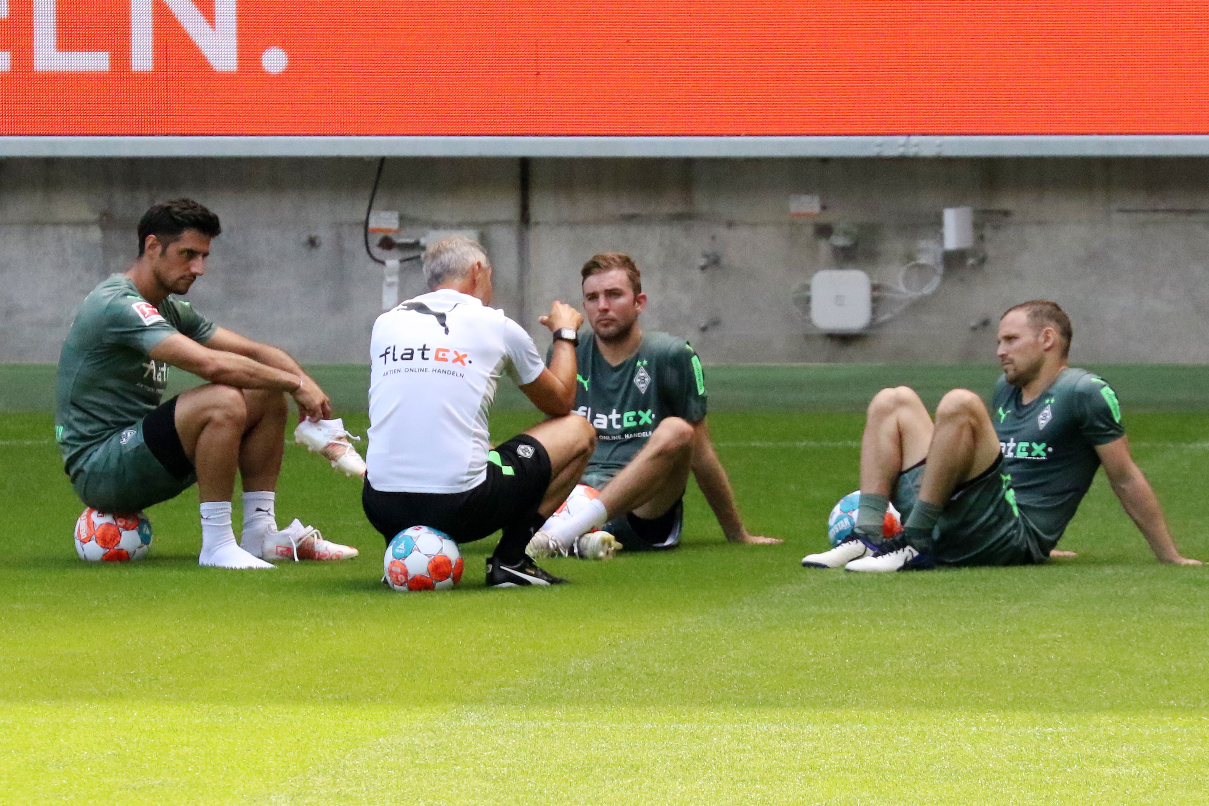 Gladbachs Christoph Kramer (Mitte) nach der Trainingseinheit am 4. Juli 2021 im Gespräch mit seinen Teamkollegen Lars Stindl (links) und Tony Jantschke (rechts) sowie Trainer Adi Hütter (vorne) im Borussia-Park.