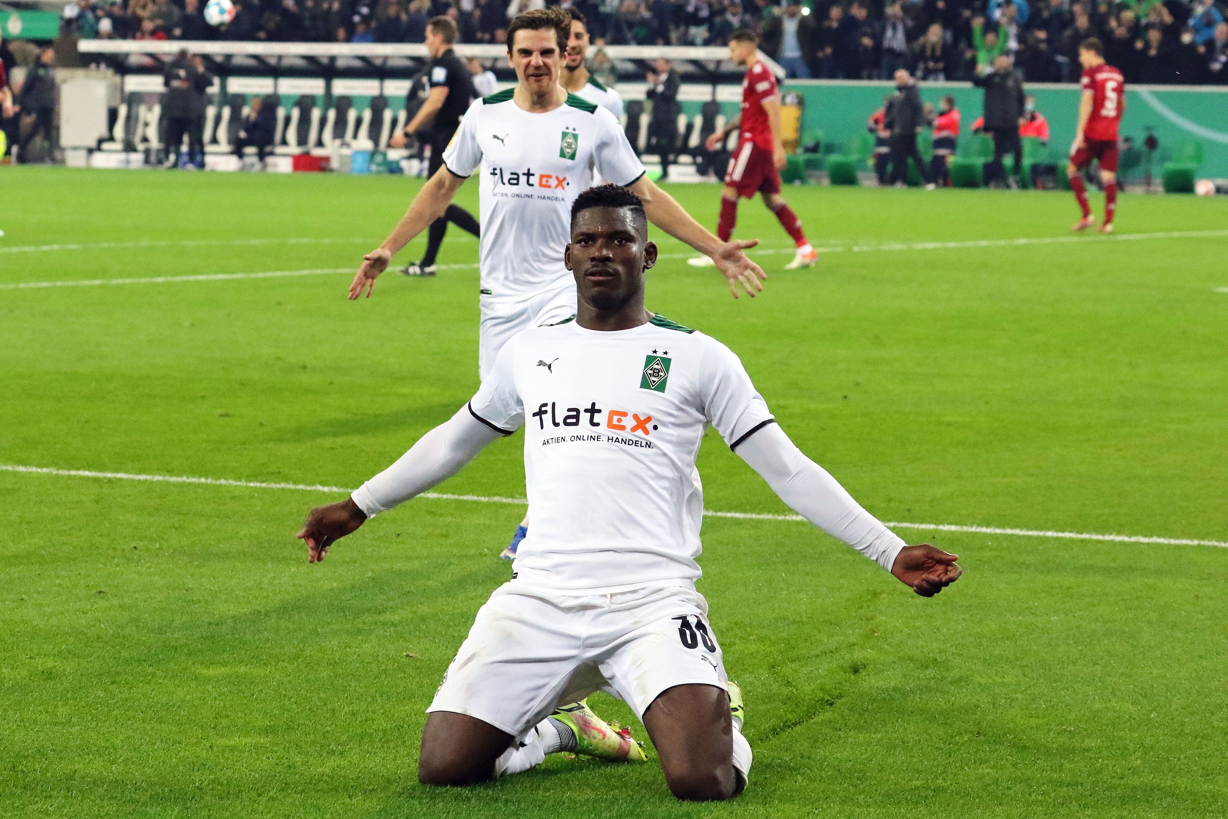 Gladbach-Stürmer Breel Embolo bejubelt einen seiner Treffer beim 5:0-Sieg im DFB-Pokal gegen Bayern München am 27. Oktober 2021 im Borussia-Park. Embolo breitet kniend seine Arme aus.